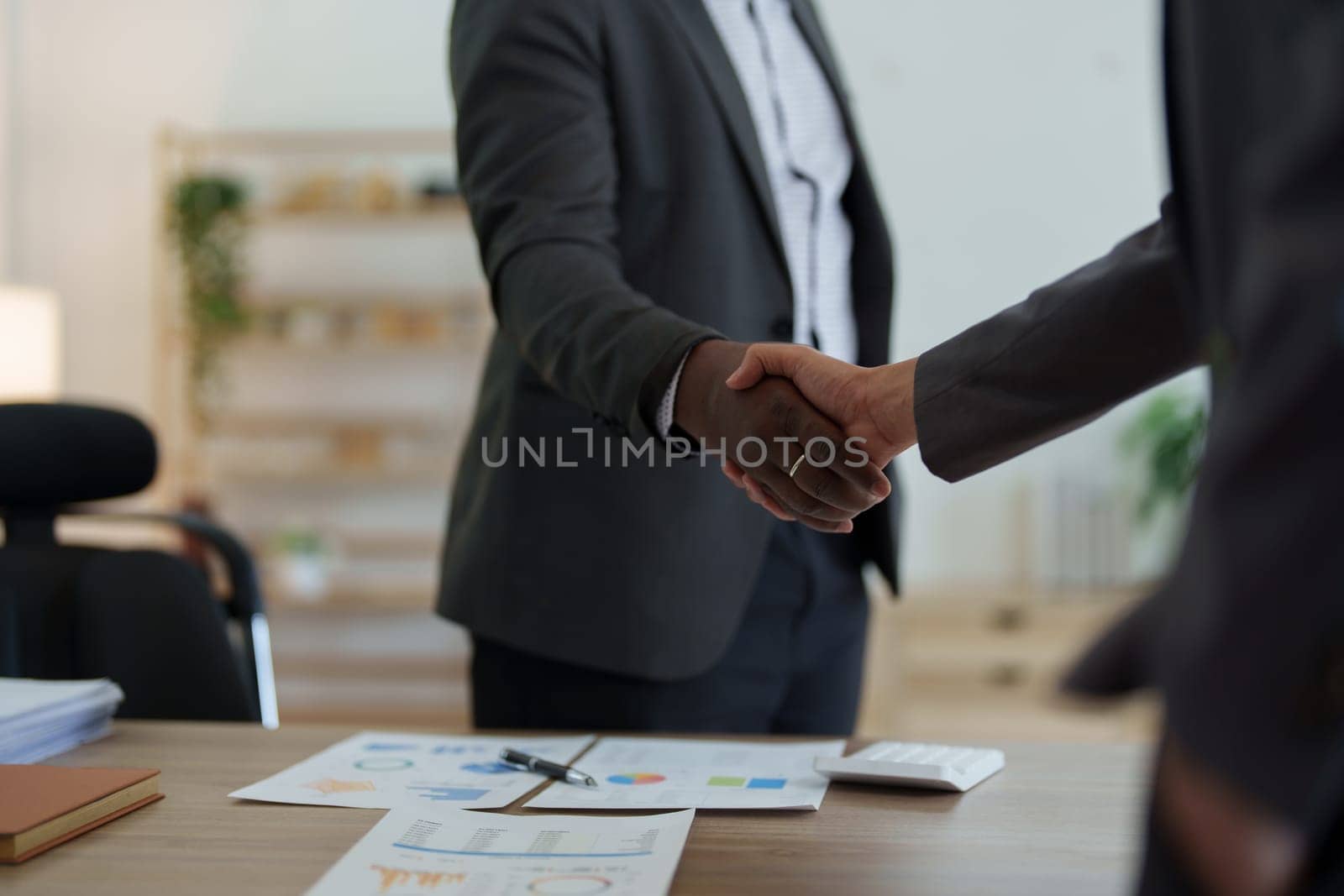 african american and asian people hand shaking successful corporate partnership deal welcoming opportunity in office agreement professional greeting meeting colleagues partners by Manastrong