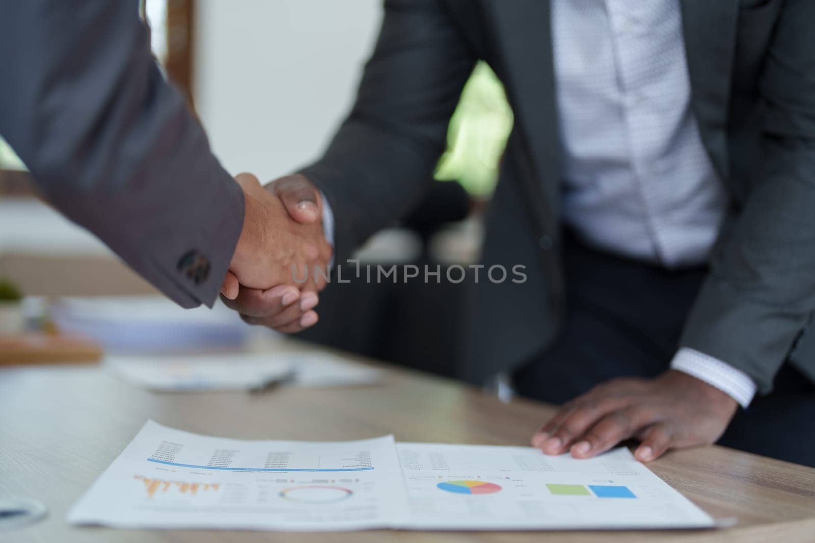 african american and asian people hand shaking successful corporate partnership deal welcoming opportunity in office agreement professional greeting meeting colleagues partners by Manastrong