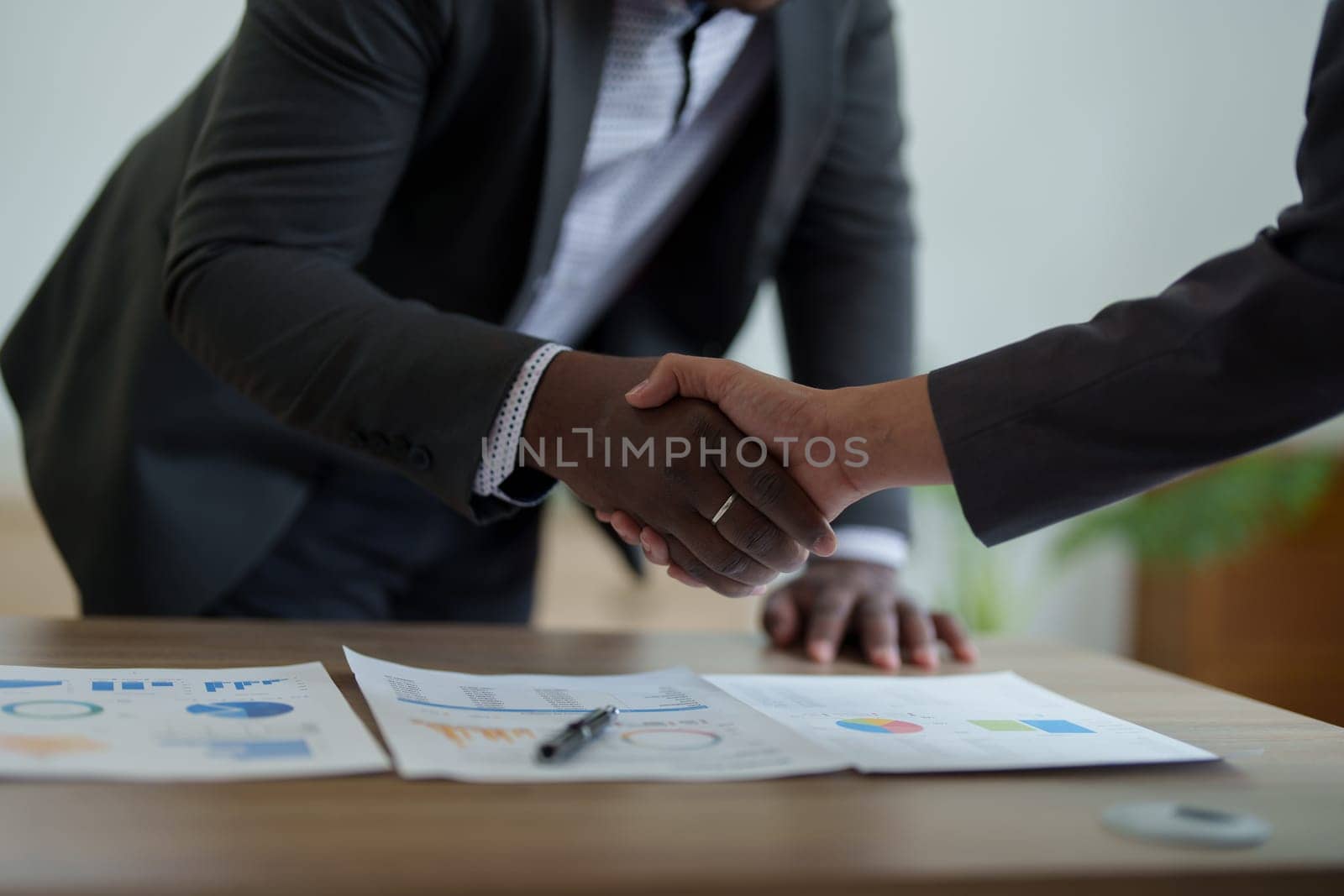 african american and asian people hand shaking successful corporate partnership deal welcoming opportunity in office agreement professional greeting meeting colleagues partners by Manastrong