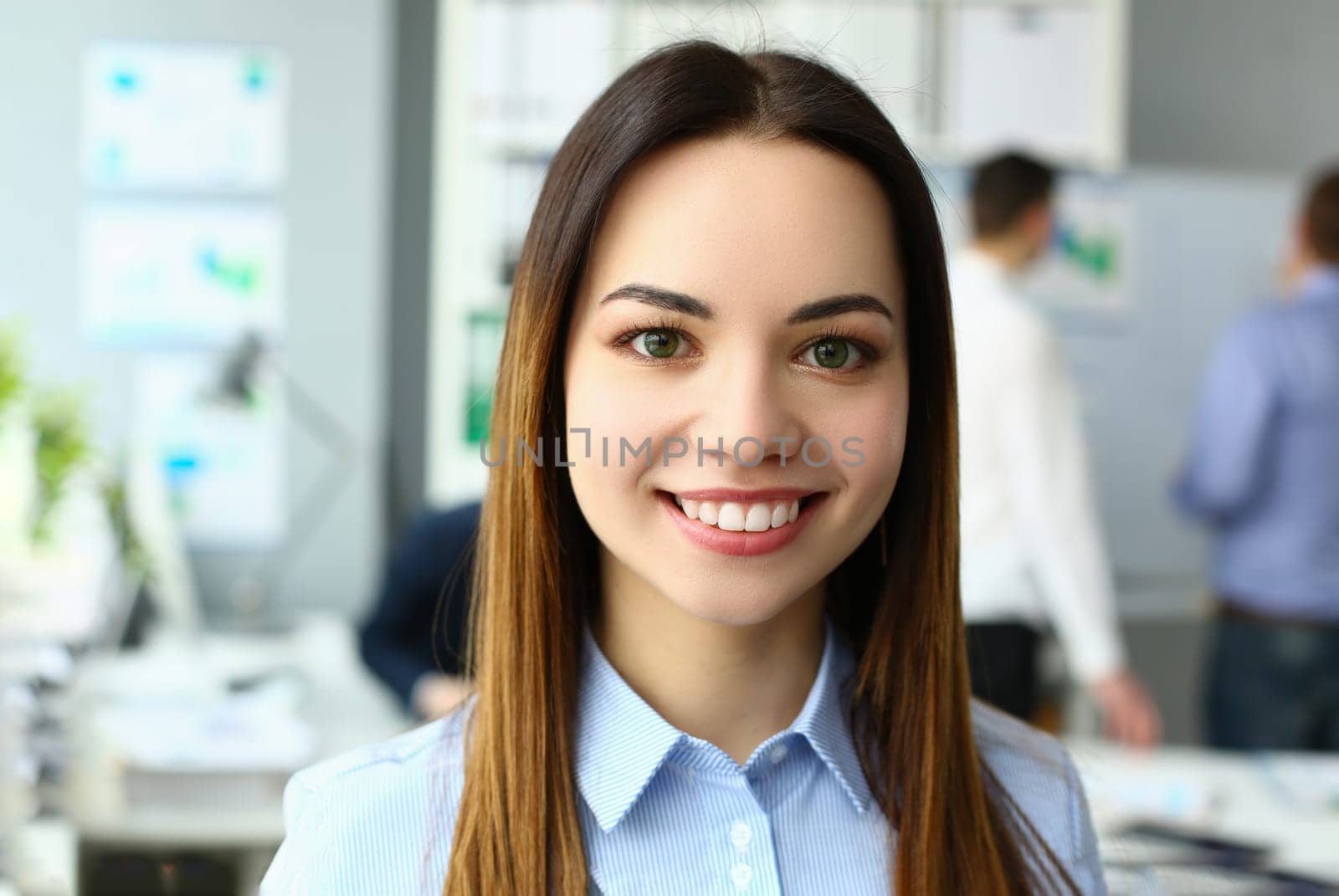 Portrait of beautiful joyful emotionally happy businesswoman in background of business colleague by kuprevich