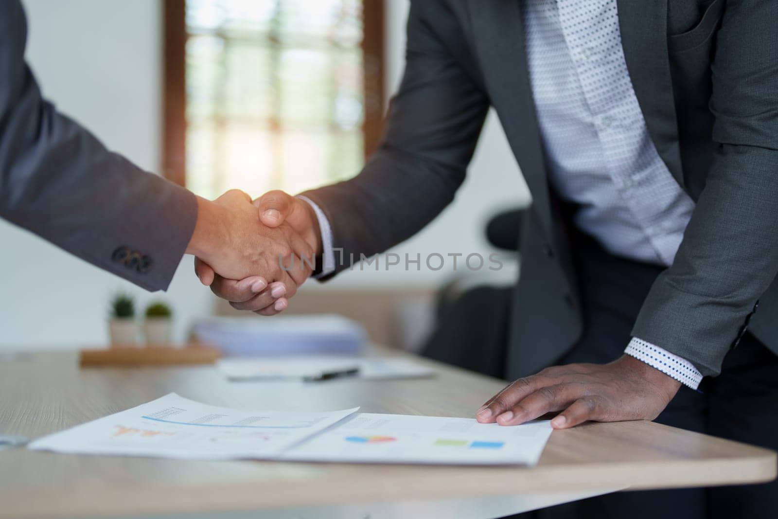 african american and asian people hand shaking successful corporate partnership deal welcoming opportunity in office agreement professional greeting meeting colleagues partners by Manastrong