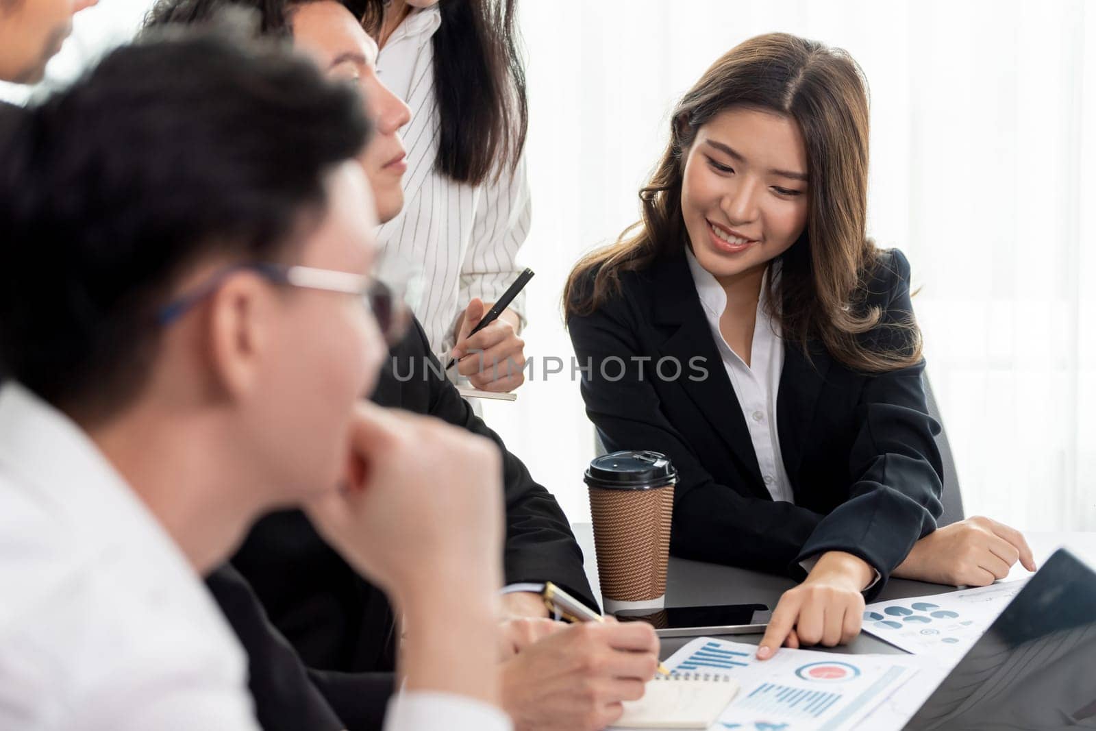 Harmony in office concept as business people analyzing dashboard paper together in workplace. Young colleagues give ideas at manager desk for discussion or strategy planning about project.