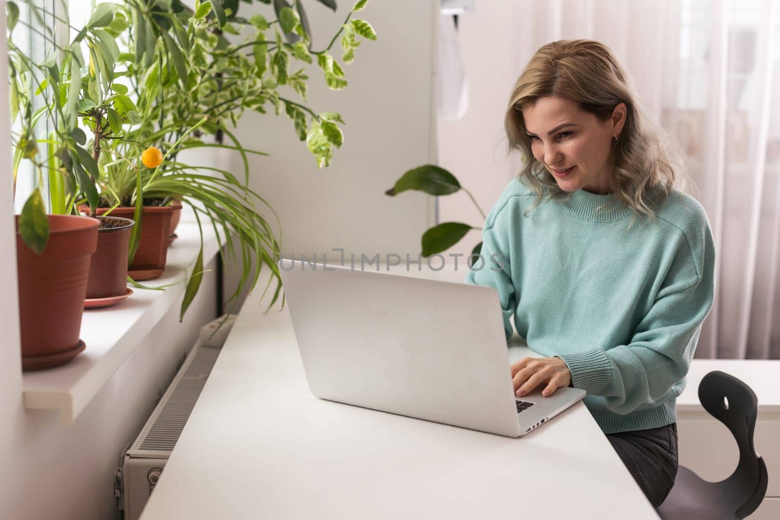 Side view head shot smiling mixed race lady freelancer wearing headset, communicating with client via video computer call. Millennial pleasant professional female tutor giving online language class.