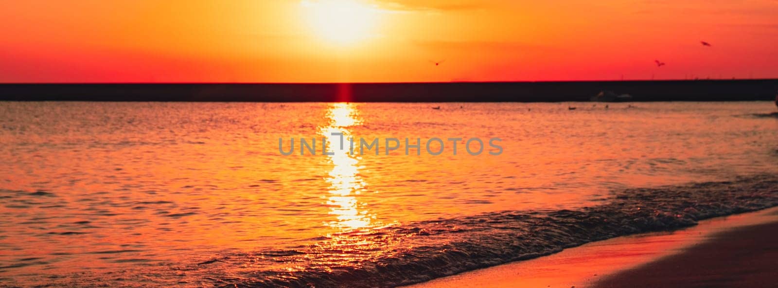 Reflection of sunlight over sea surface at sunset. Orange and gold blue sky. Dramatic Yellow sun coming out of the sea. Majestic summer landscape by anna_stasiia