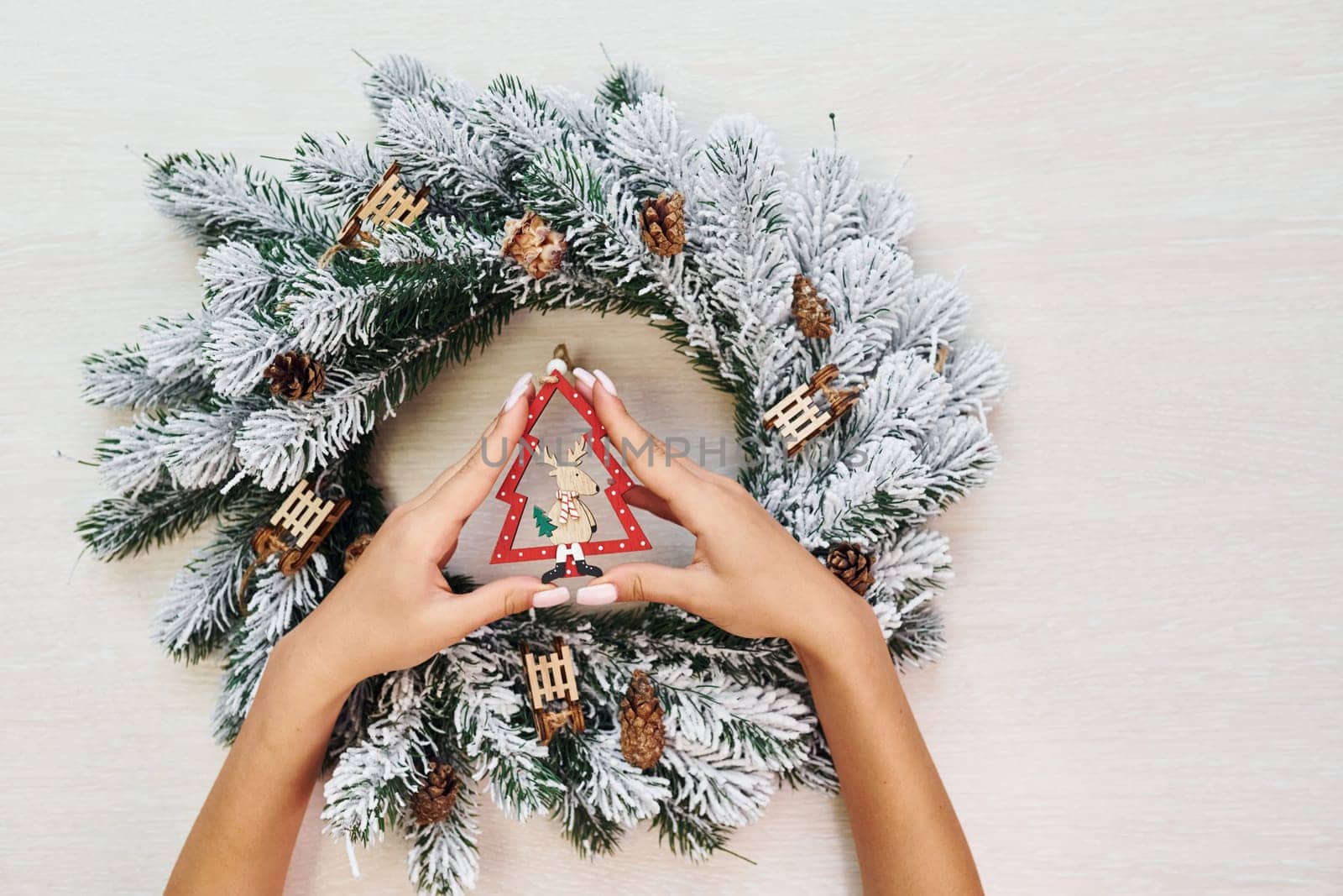 Woman's hands holds toys. Top view of christmas festive texture with new year decorations by Standret