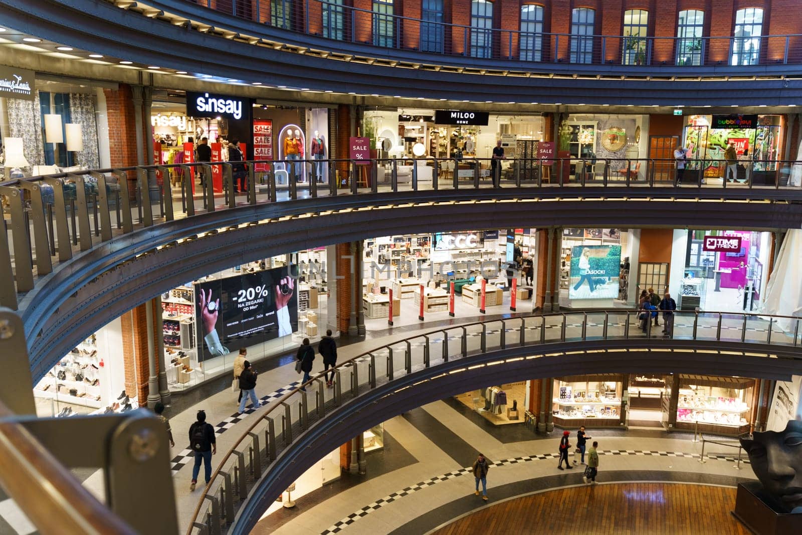 Poznan, Poland - February 4, 2023: Brand stores on different floors in the shopping center, located in a semicircle.