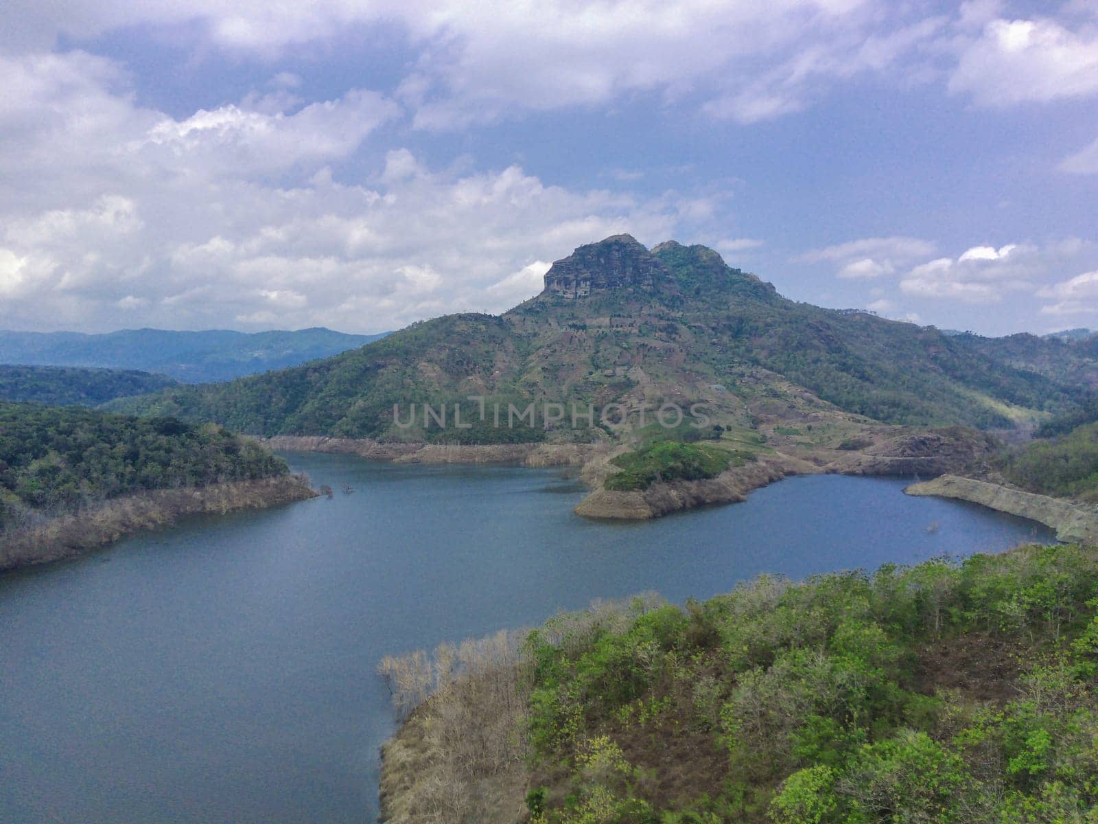 Aerial view of lake against the hills and the cloudy sky
