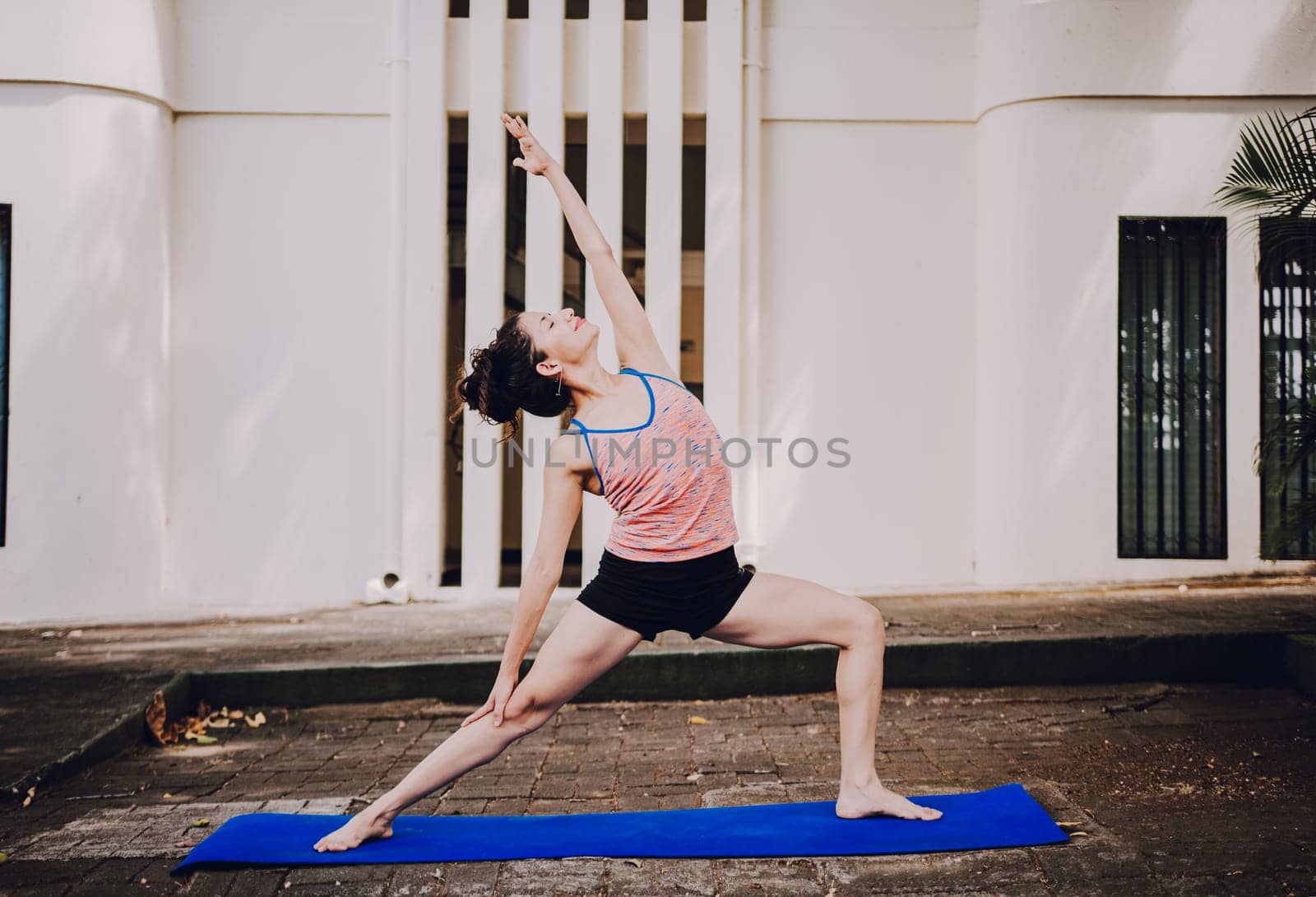 Young woman doing reverse warrior yoga outdoors. Girl doing yoga viparita virabhadrasana Attractive girl practicing reverse warrior yoga outdoors