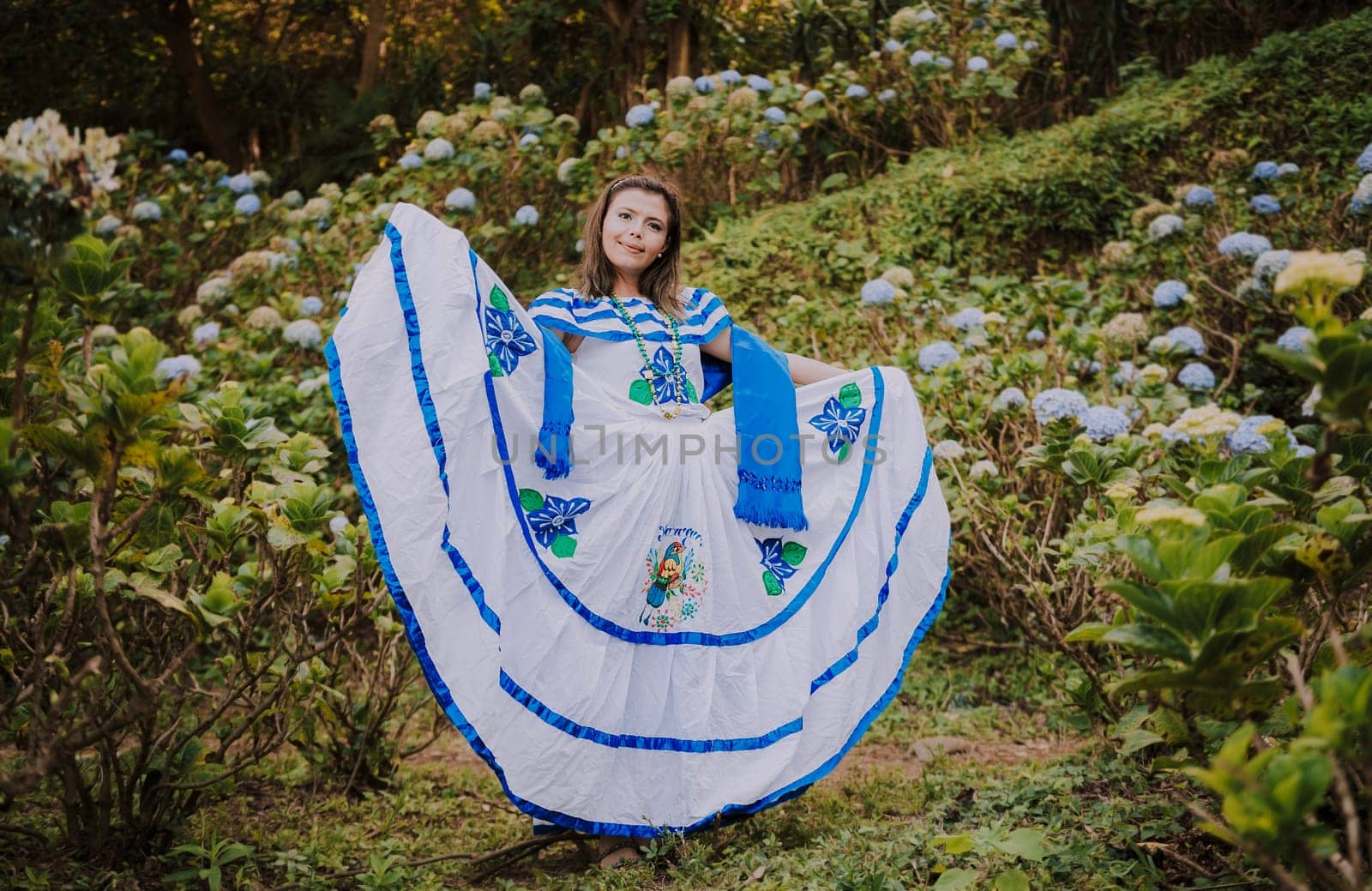 Girl in Nicaraguan national folk costume. Young Nicaraguan woman in traditional folk costume in a field of Milflores, Smiling girl in national folk costume in a field surrounded by flowers