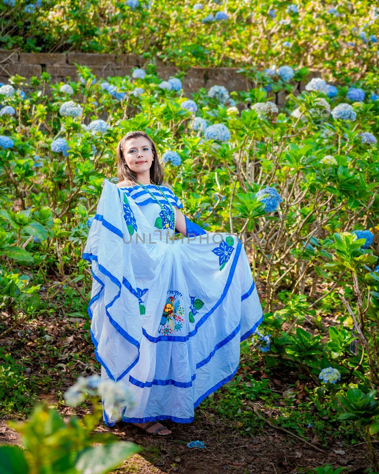 Nicaraguan woman in traditional folk costume in a field of flowers, Portrait of young Nicaraguan woman in traditional folk costume in a field of flowers by isaiphoto