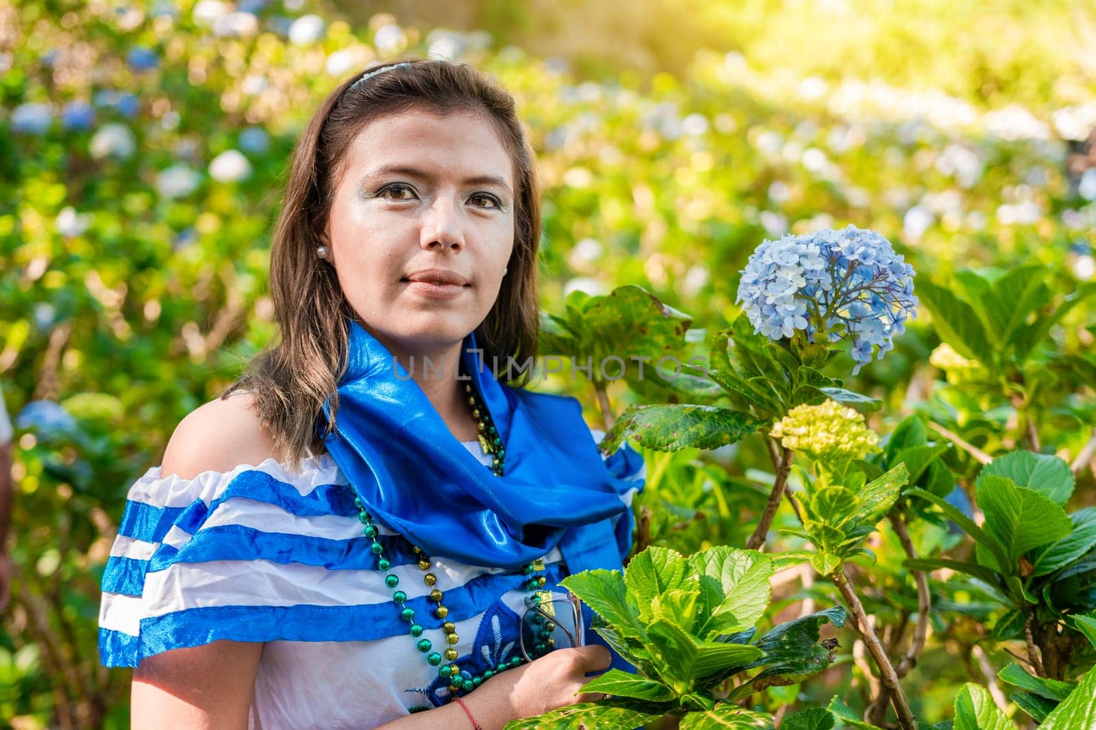 Portrait of smiling woman in national folk costume in a field of flowers. Nicaraguan national folk costume, Young Nicaraguan woman in traditional folk costume in a field of Milflores by isaiphoto