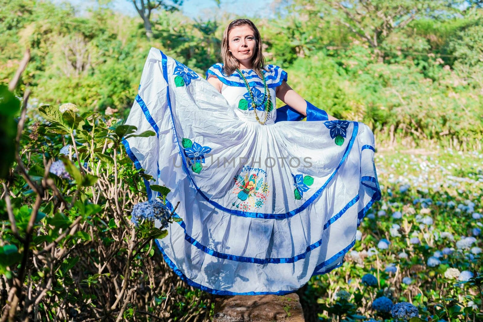 Nicaraguan woman in traditional folk costume in a field of Milflores, Smiling woman in national folk costume in a field surrounded by flowers. People in Nicaraguan national folk costume