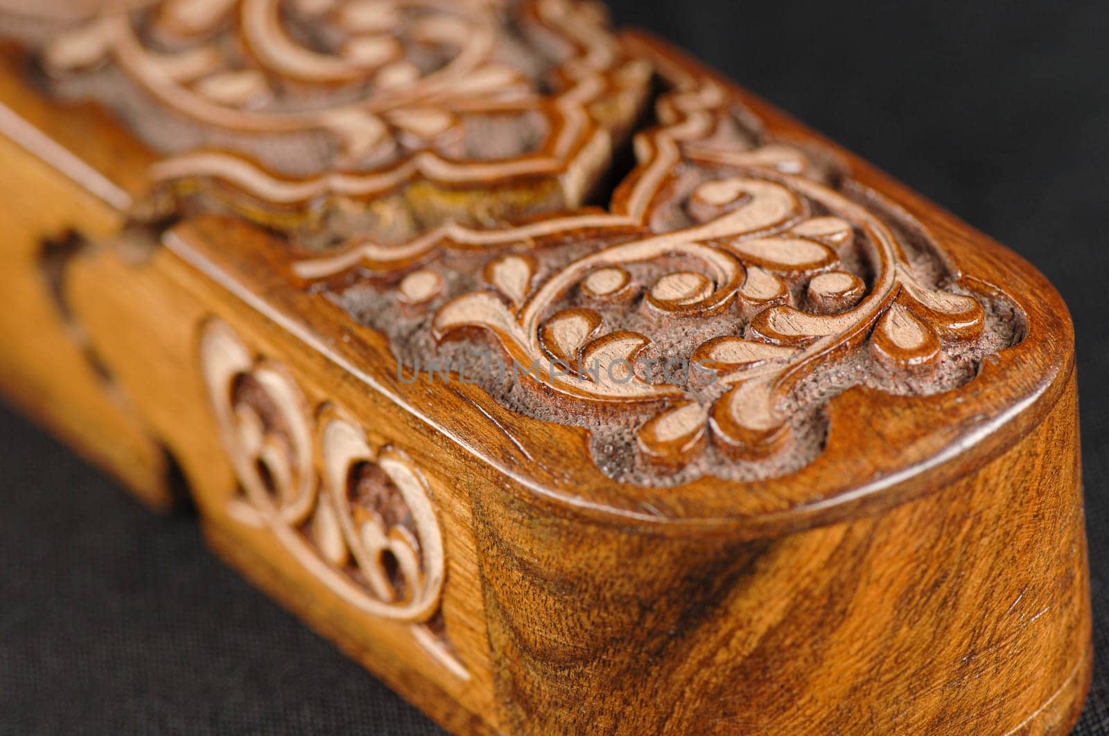 A close-up artistic wood carving on the pencil case on a black background. Central Asia, Uzbekistan by A_Karim