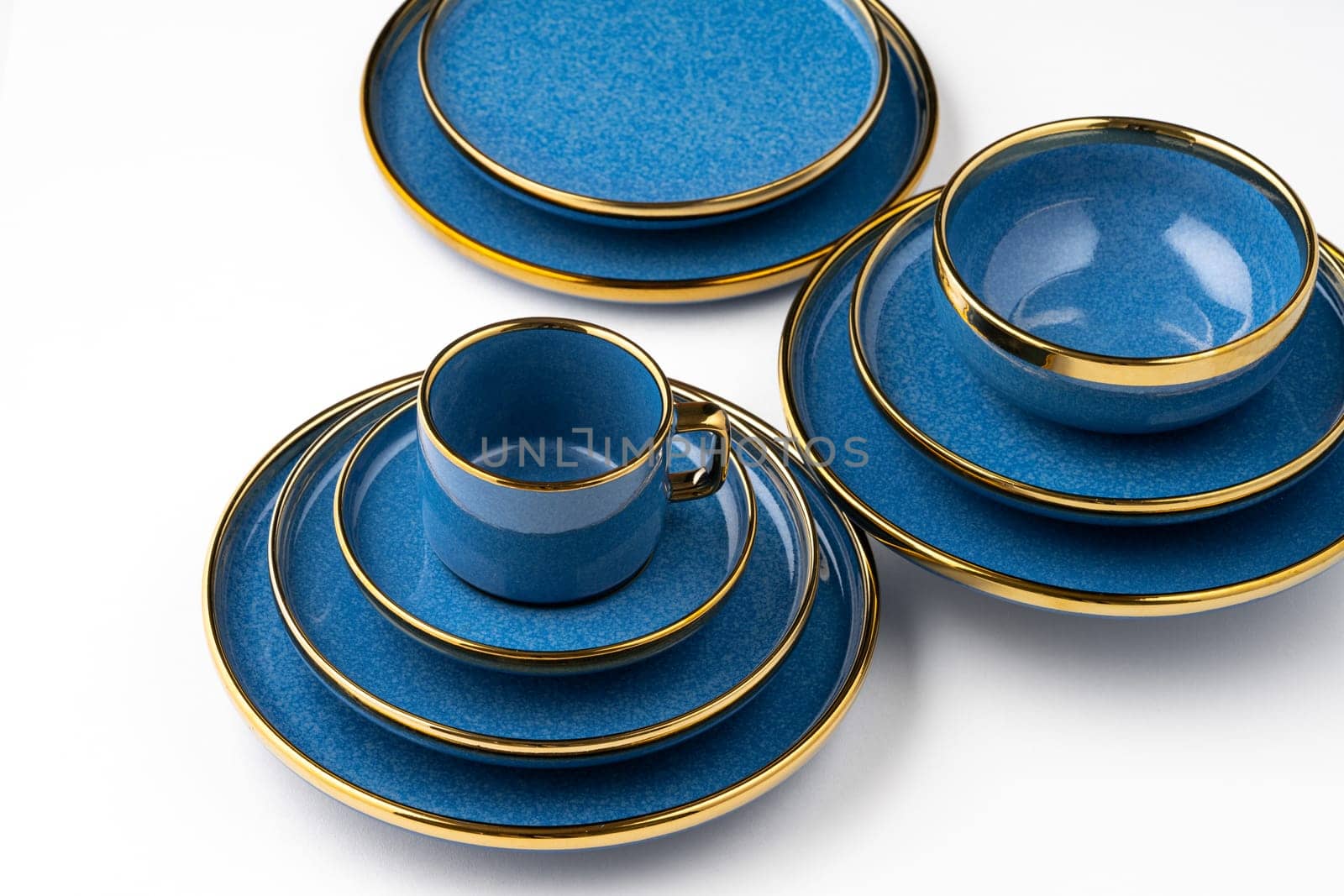 A set of blue ceramic plates and cup on a white background