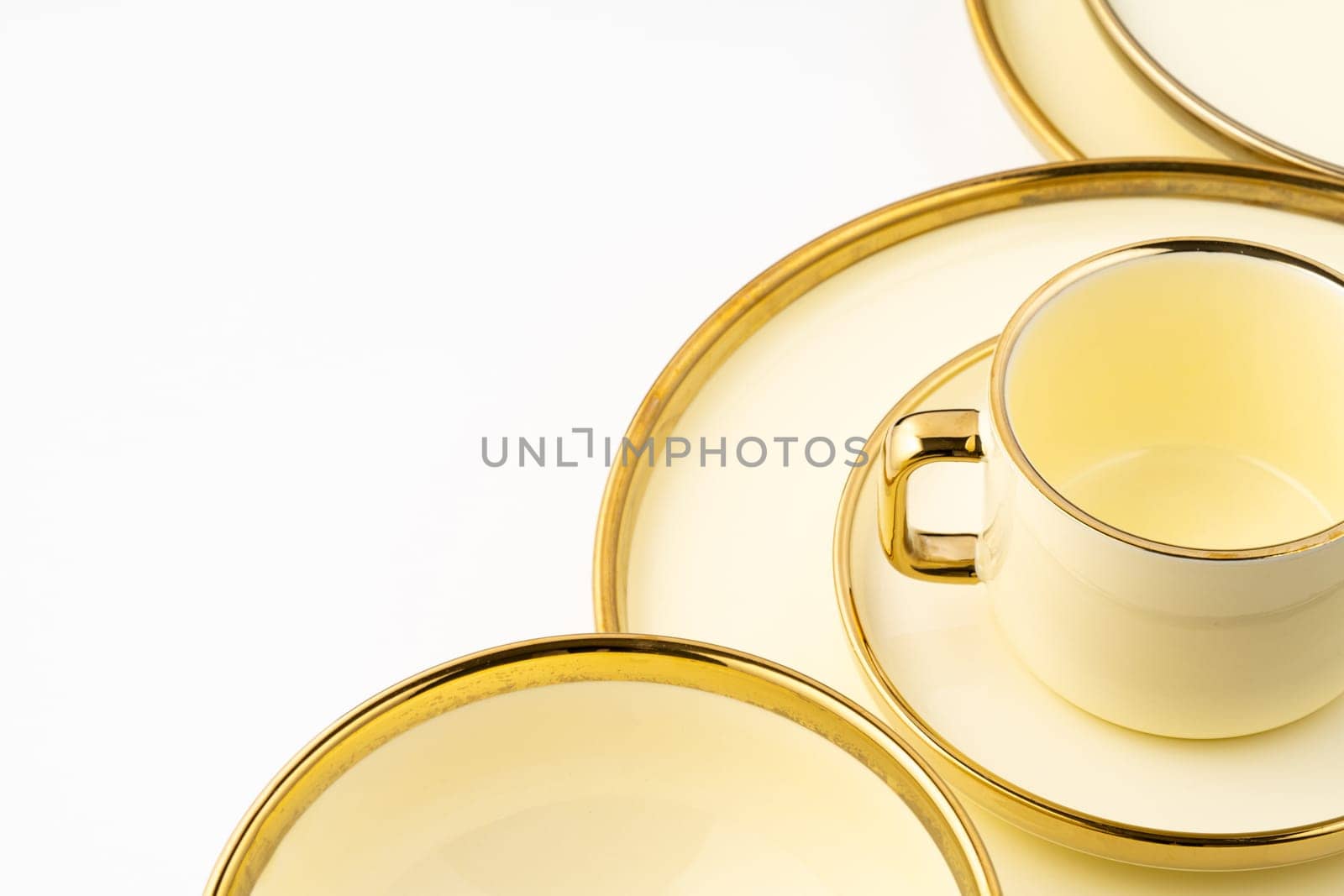 A set of golden luxury ceramic kitchen utensils on a white background