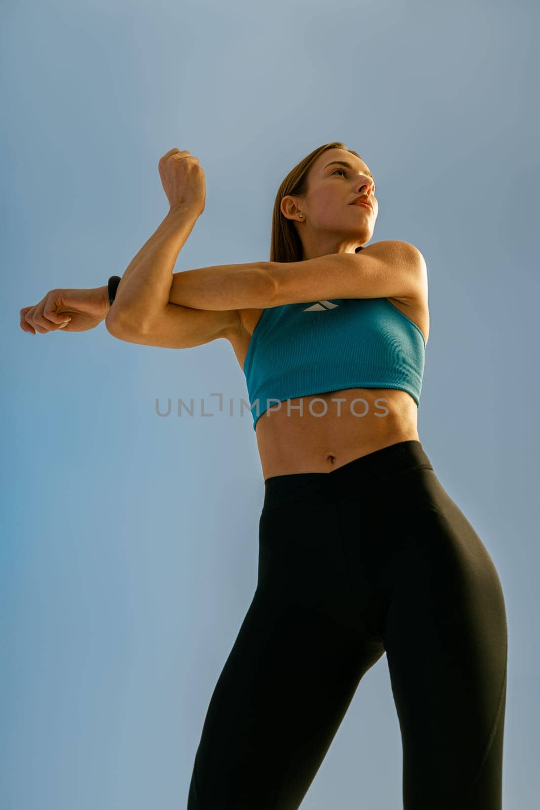Bottom view of woman doing warm up hands exercises and stretching her body preparing to gym by Yaroslav_astakhov