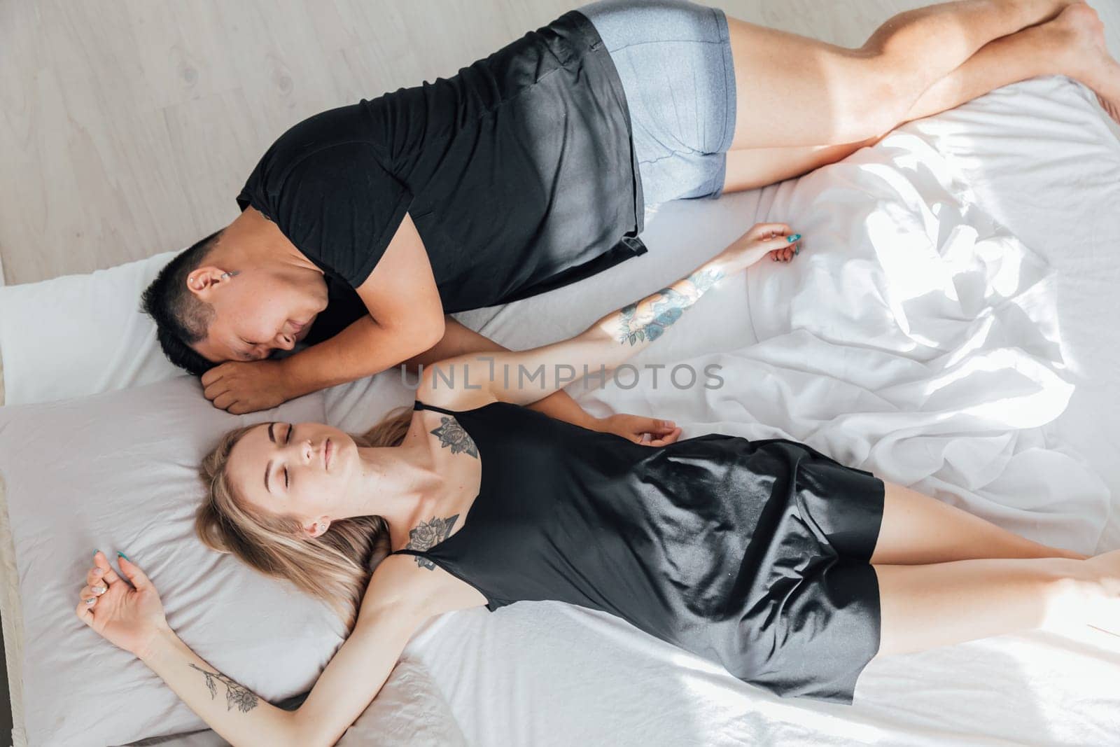 man and a woman lie in bed in the morning in the bedroom