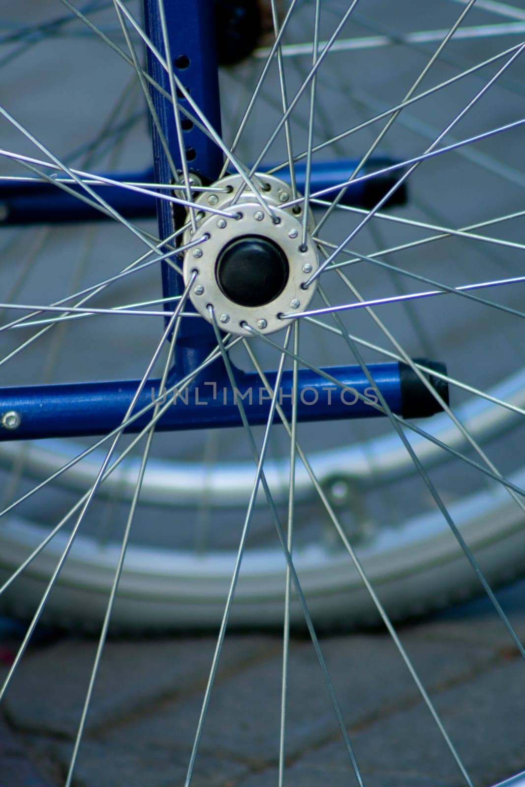 closeup of the axle and spokes of a standing wheelchair. This photo is perfect to represent concepts associated with health, the elderly and other diseases or nursing homes