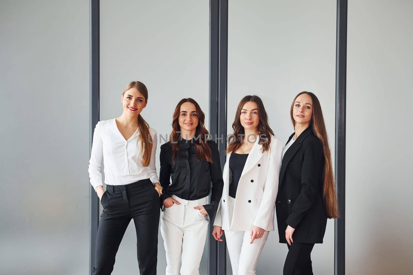 Group of adult women that in formal clothes is indoors in the office together.