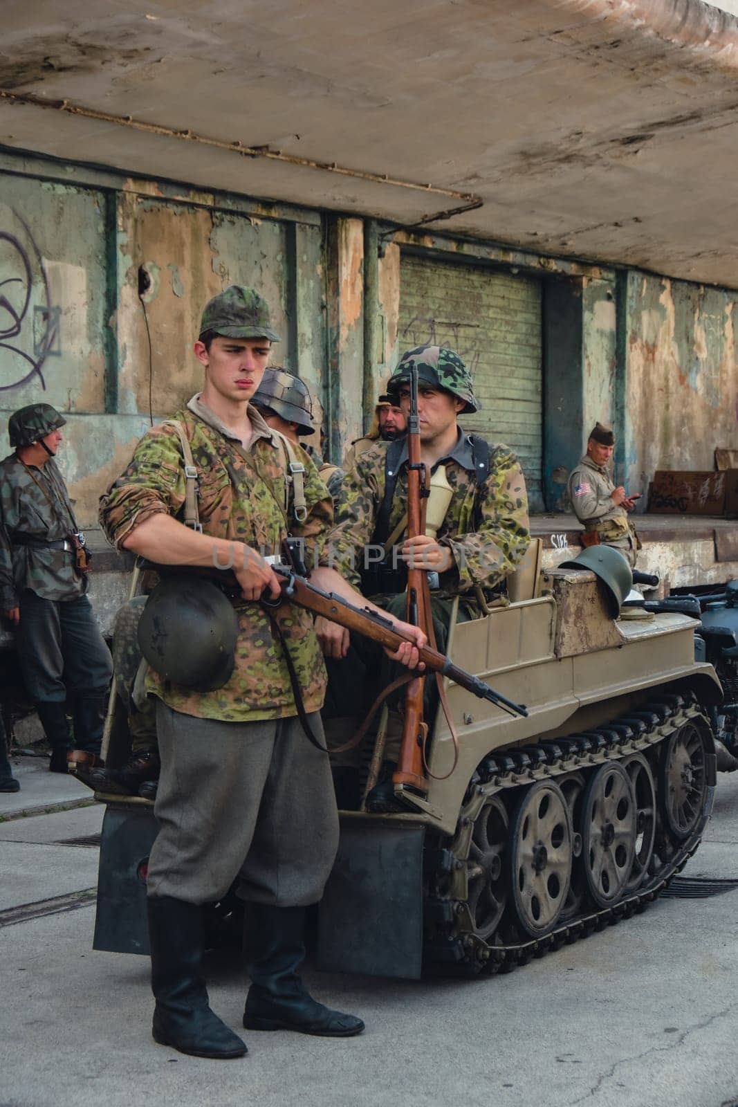 Hel, Poland - August 2022 Military troops marching during 3 May Polish Constitution Day ceremonial patriotic parade. Polish armed forces tanker military parade. Old guns and cars. Feast of Polish Armed Forces Day, American soldiers with US flag on parade Nato Vehicles Military Equipment