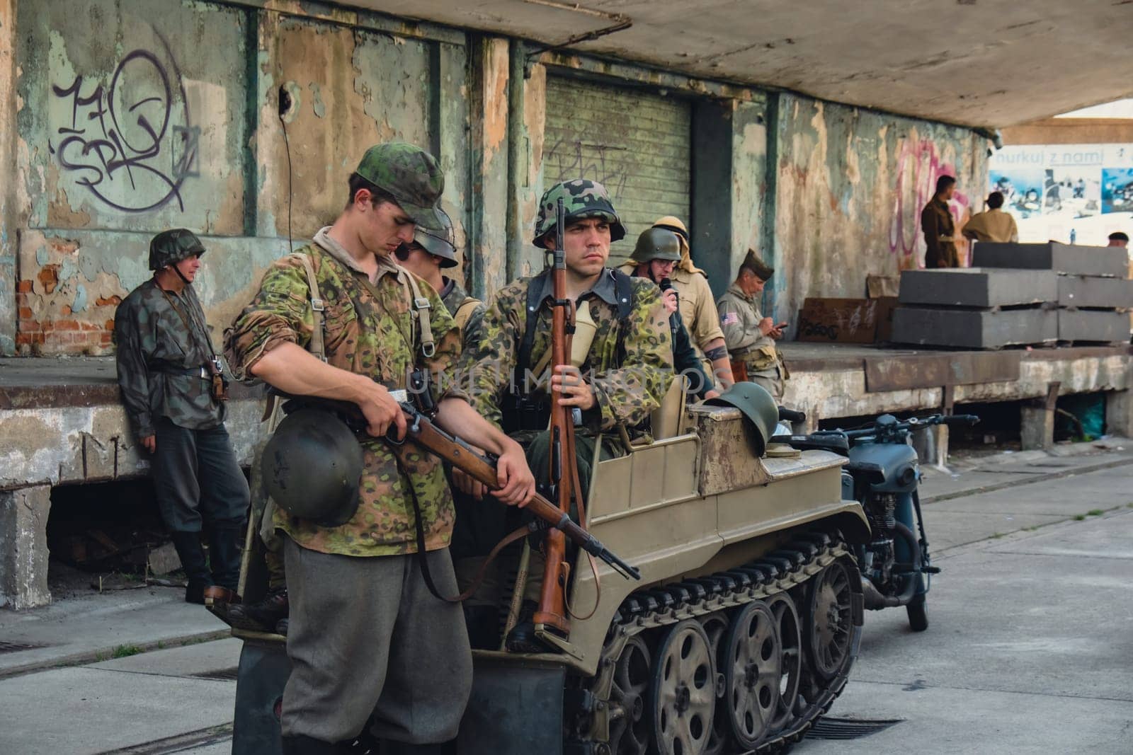 Hel, Poland - August 2022 Military troops marching during 3 May Polish Constitution Day ceremonial patriotic parade. Polish armed forces tanker military parade. Old guns and cars. Feast of Polish Armed Forces Day, American soldiers with US flag on parade Nato Vehicles Military Equipment