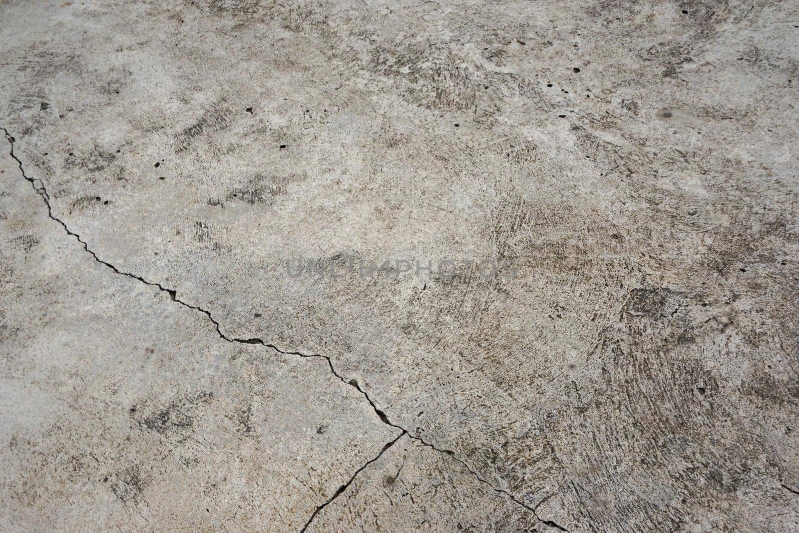The cement floor is not grey. There are cracks. Divide the cement into 3 parts unequal size. Texture or background.