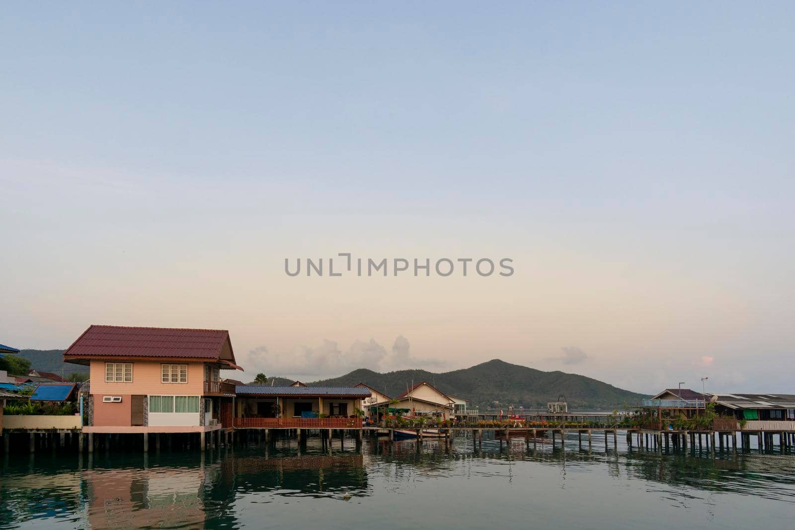 Fisherman's house and seaside house in Sattahip, reflecting with the water surface. Bright sky