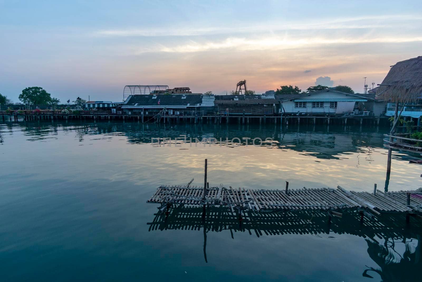 Fisherman's house and seaside house in Sattahip, reflecting with the water surface. Bright sky