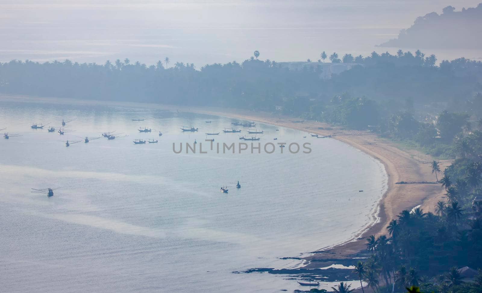 Shallow fishing boats anchor at the beach on thick fog days.	