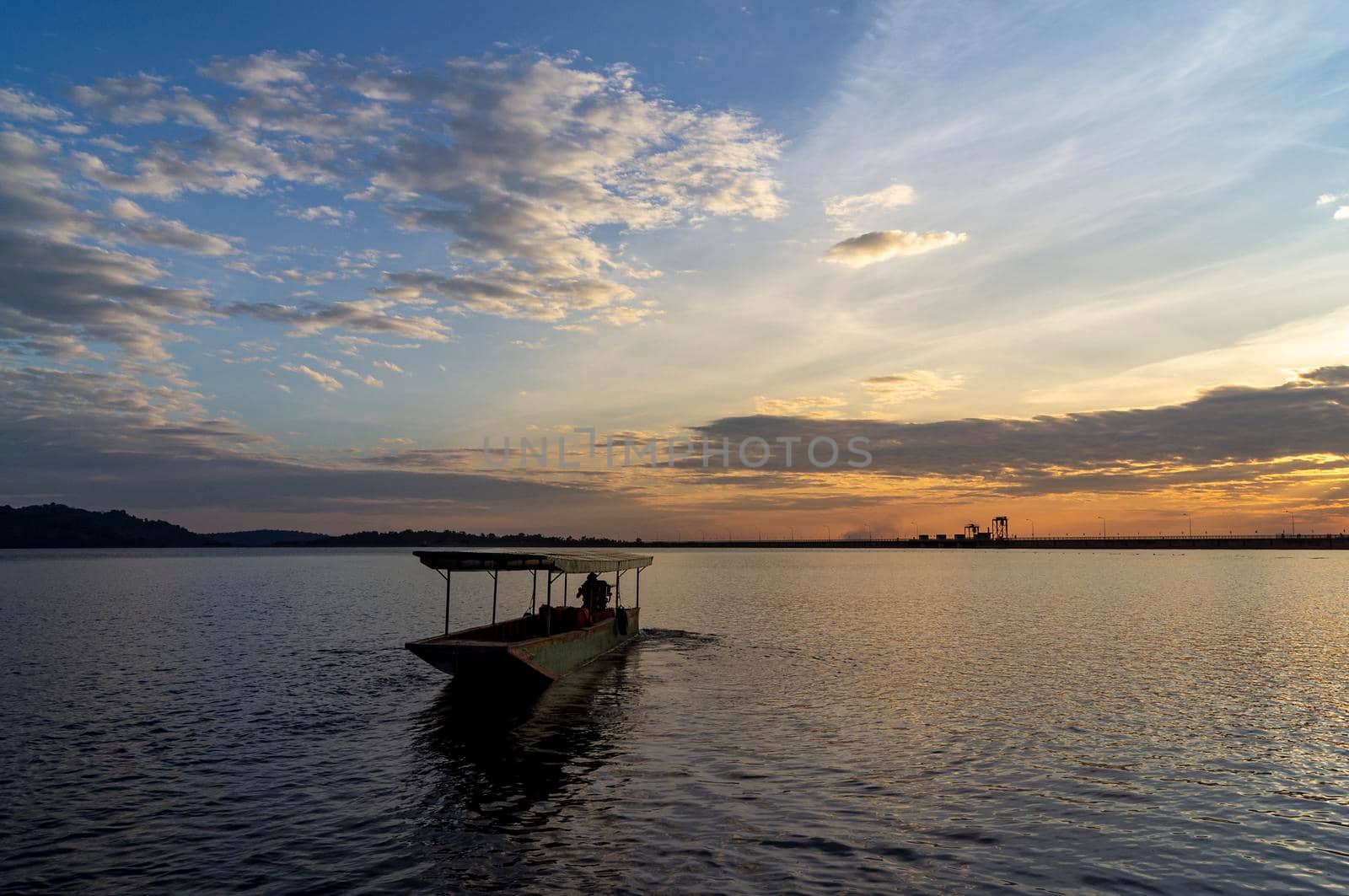 Passenger boats across the side of the dam. Evening atmosphere along the water in the dam. Sailing boat to transport people across the canal In the water storage dam