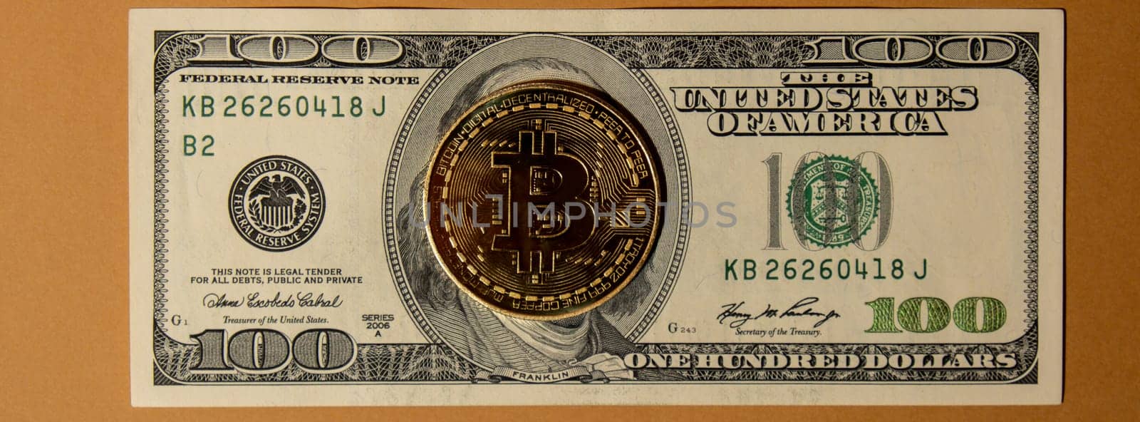Bitcoin gold coin on bills of 100 dollars American currency. Bitcoin mining trading concept. BTC golden money. Worldwide virtual internet Cryptocurrency or crypto digital payment system. Digital coin money farm in digital cyberspace