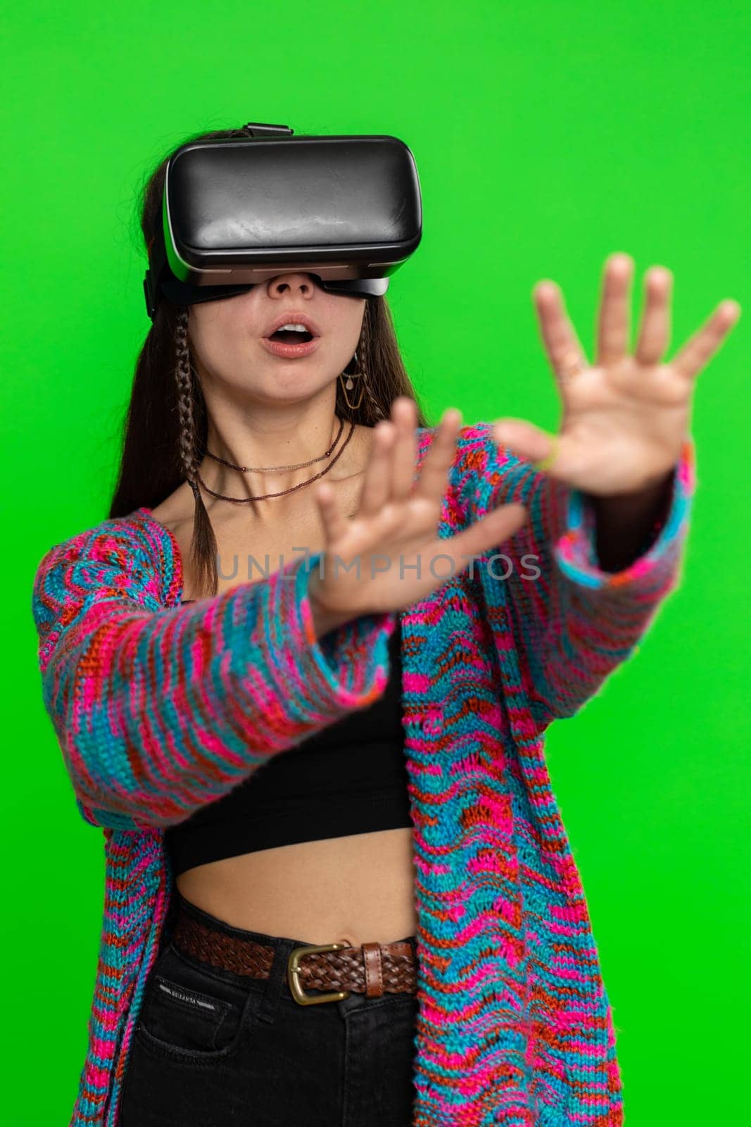 Woman using virtual reality futuristic technology VR app headset helmet to play simulation 3D 360 video game, watching film movie. Excited hippie girl isolated on chroma key background, green screen