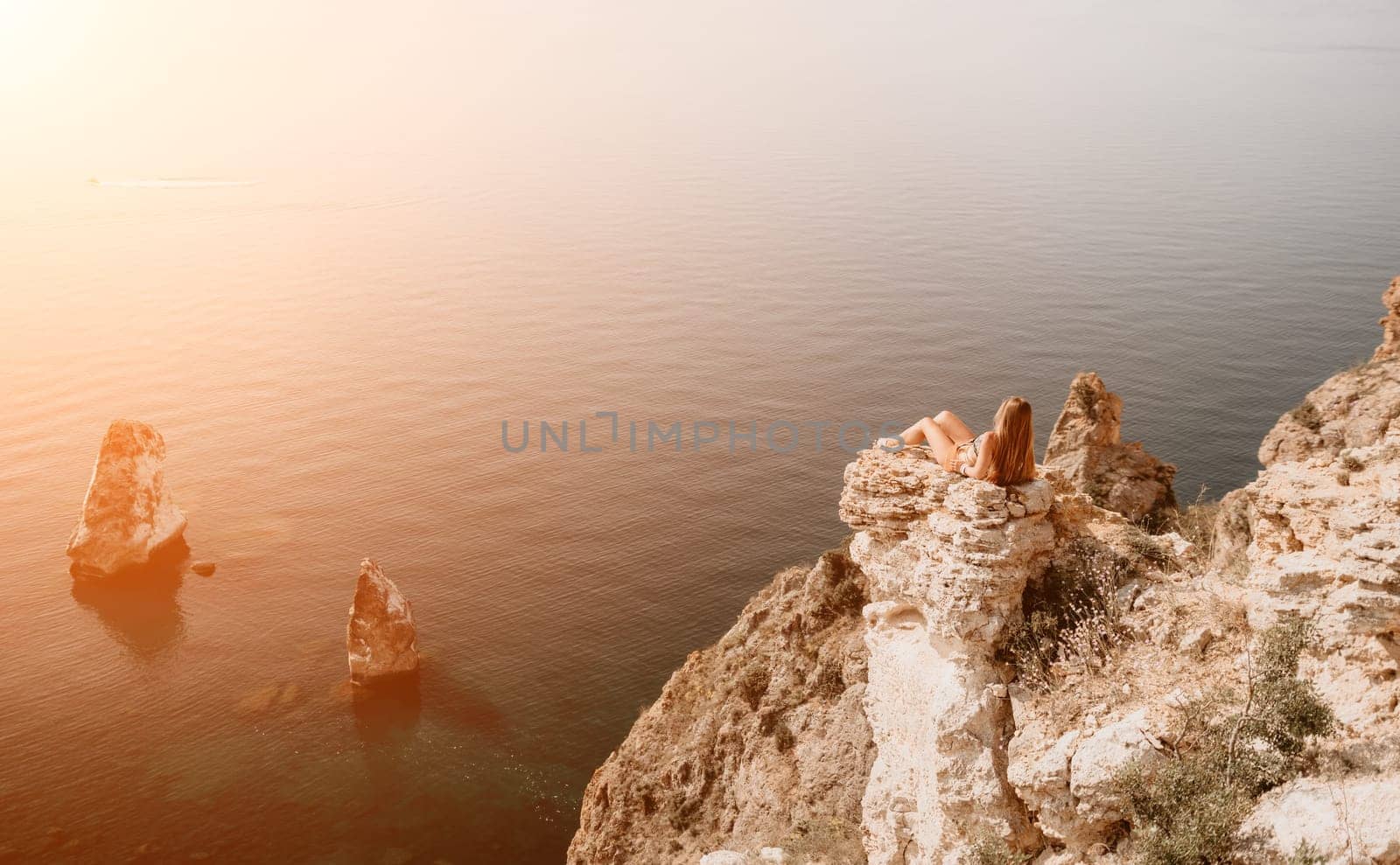 Woman travel sea. Happy tourist taking picture outdoors for memories. Woman traveler looks at the edge of the cliff on the sea bay of mountains, sharing travel adventure journey.