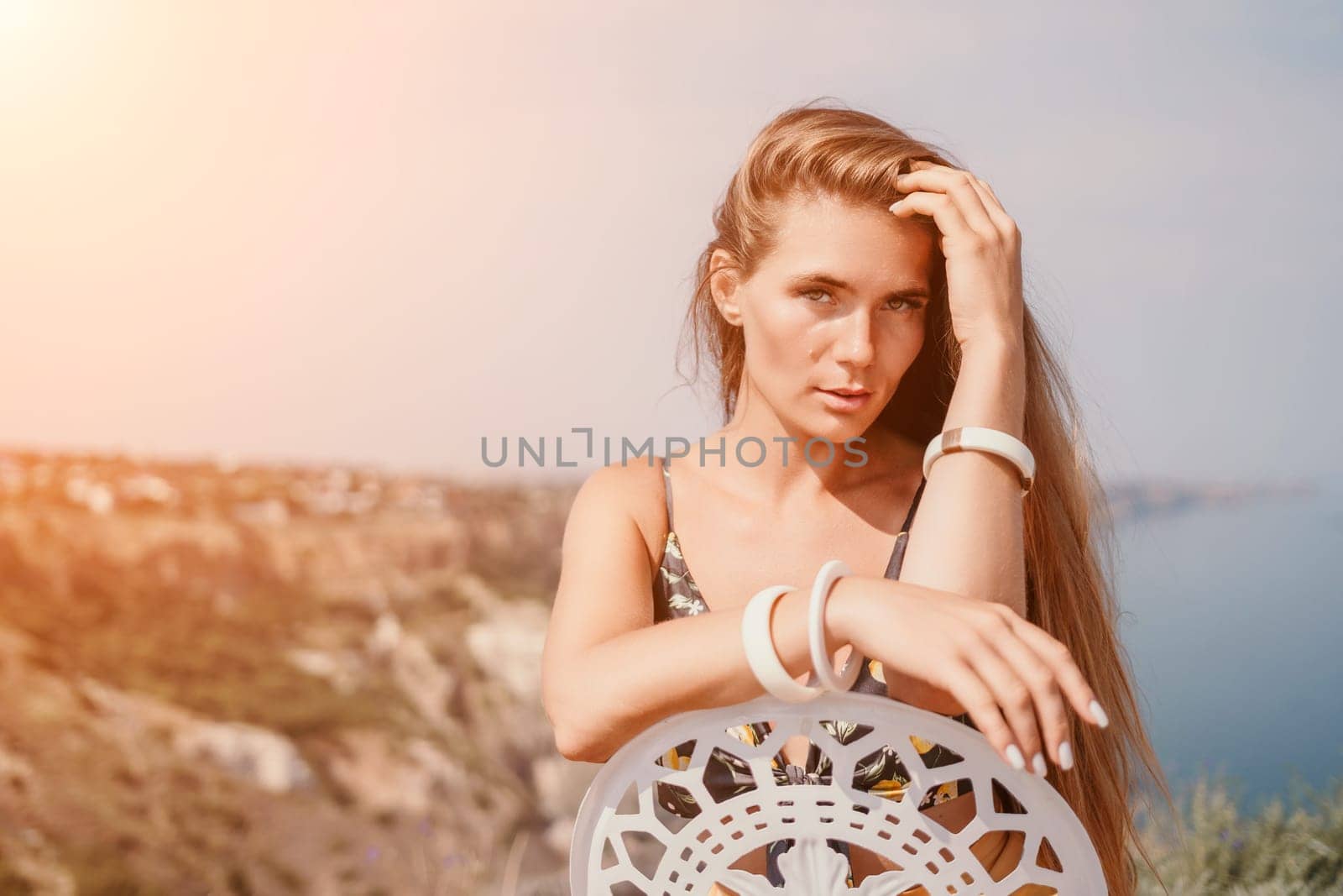 Happy woman portrait in cafe. Boho chic fashion style. Outdoor photo of young happy woman with long hair, sunny weather outdoors sitting in modern cafe