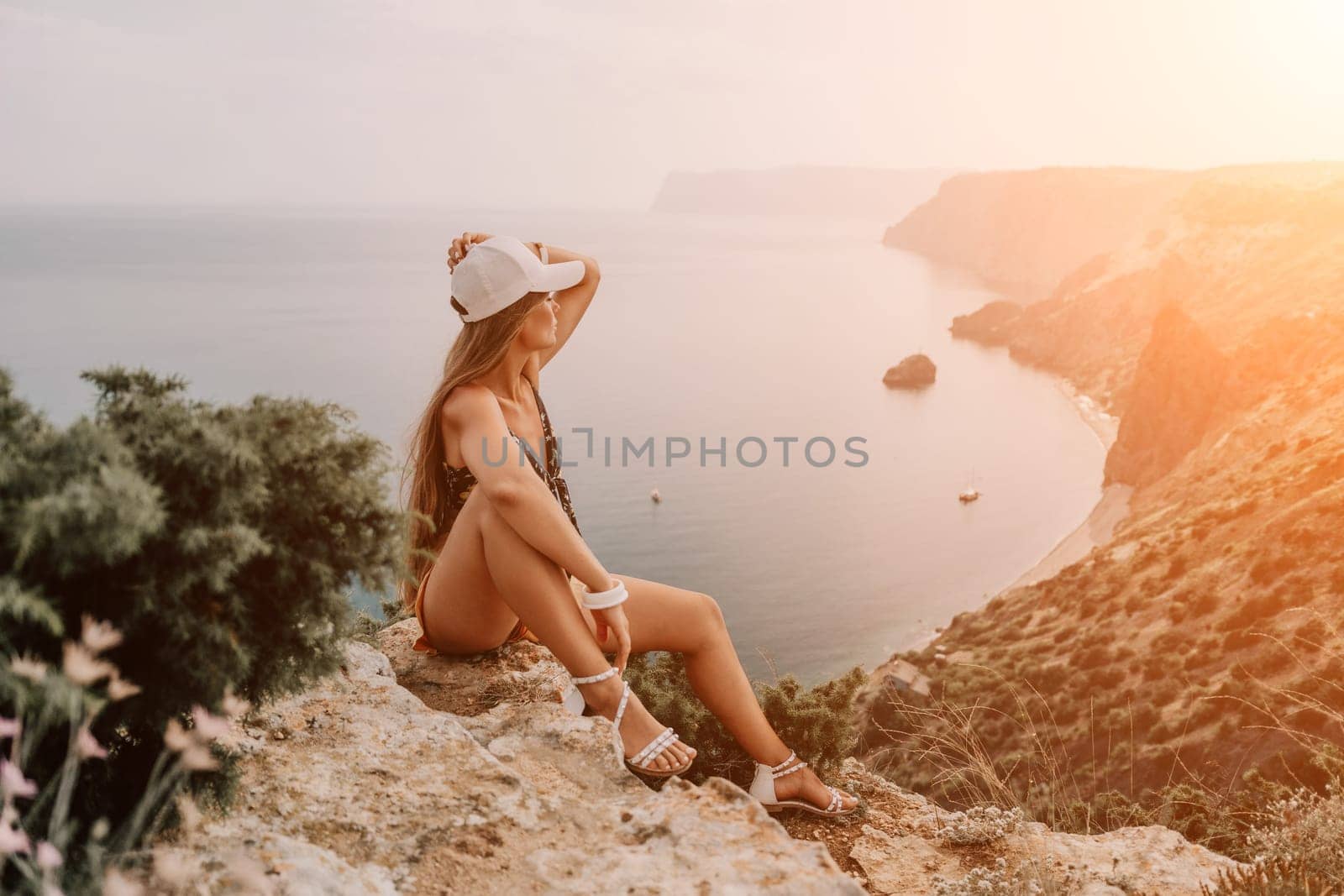 Woman travel sea. Happy tourist taking picture outdoors for memories. Woman traveler looks at the edge of the cliff on the sea bay of mountains, sharing travel adventure journey.