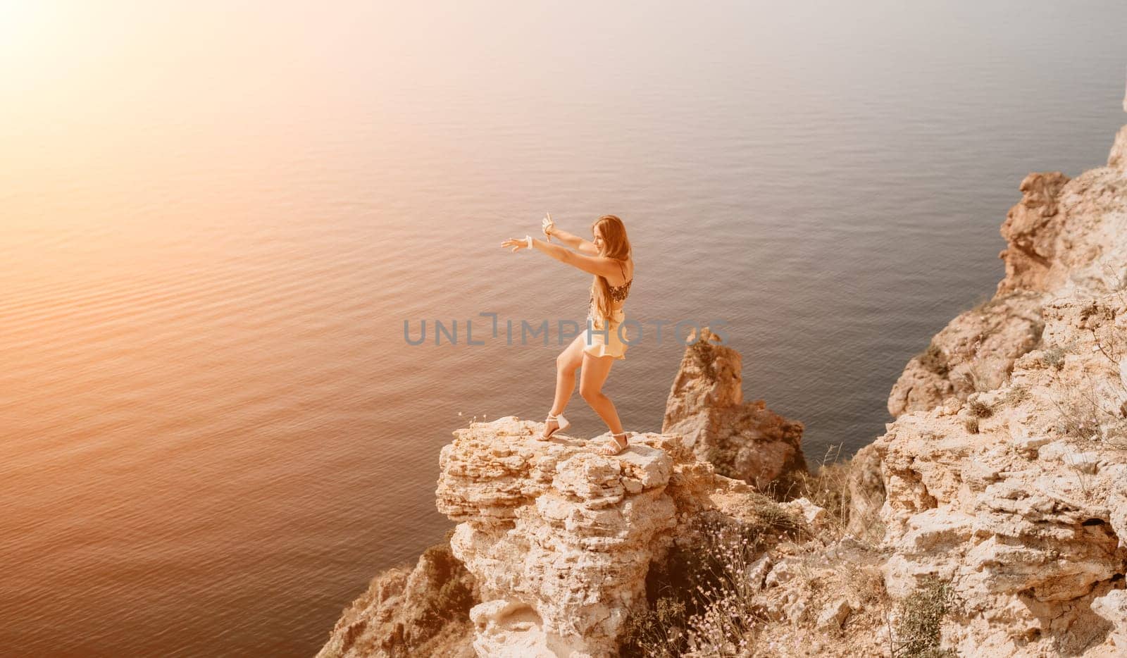 Woman travel sea. Happy tourist enjoy taking picture outdoors for memories. Woman traveler looks at the edge of the cliff on the sea bay of mountains, sharing travel adventure journey by panophotograph