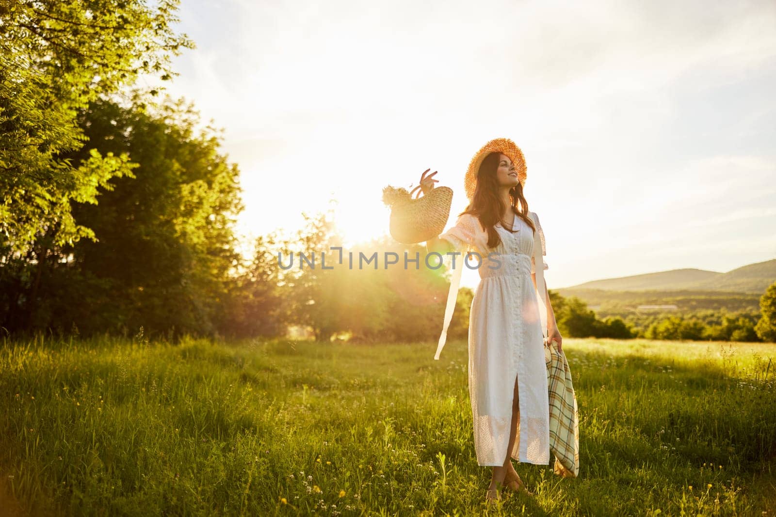 horizontal photo of a woman in a long light dress walking through the forest, illuminated from the back by the rays of the setting sun by Vichizh
