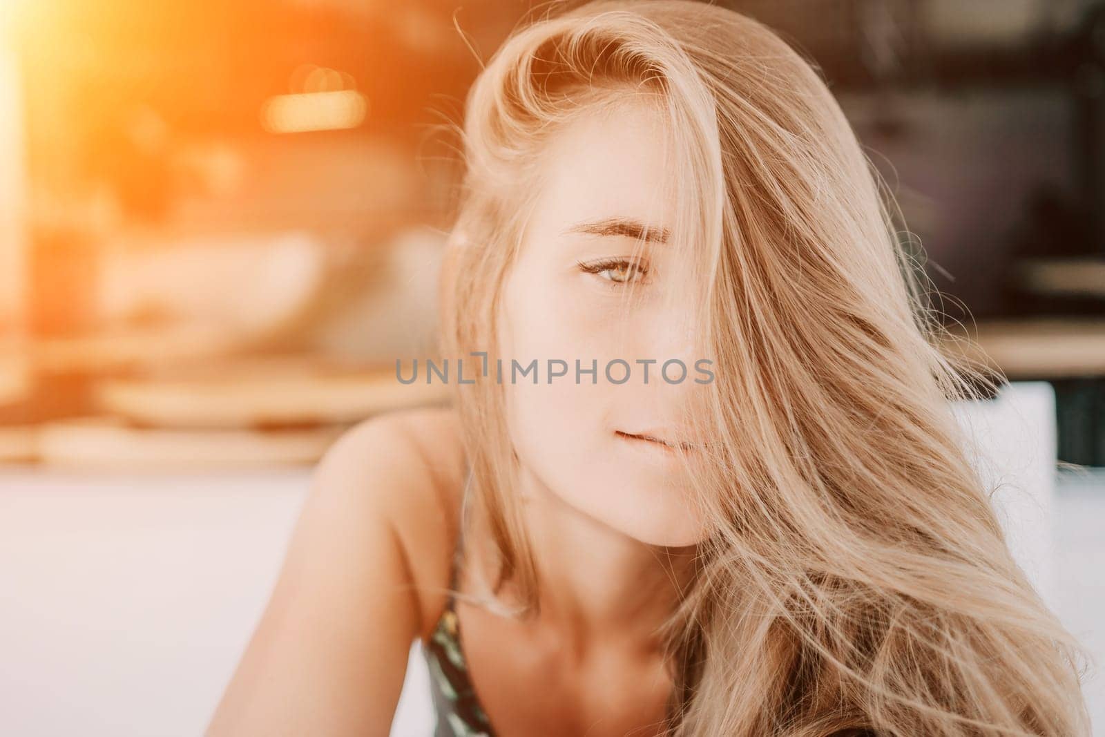 Happy woman portrait in cafe. Boho chic fashion style. Outdoor photo of young happy woman with long hair, sunny weather outdoors sitting in modern cafe