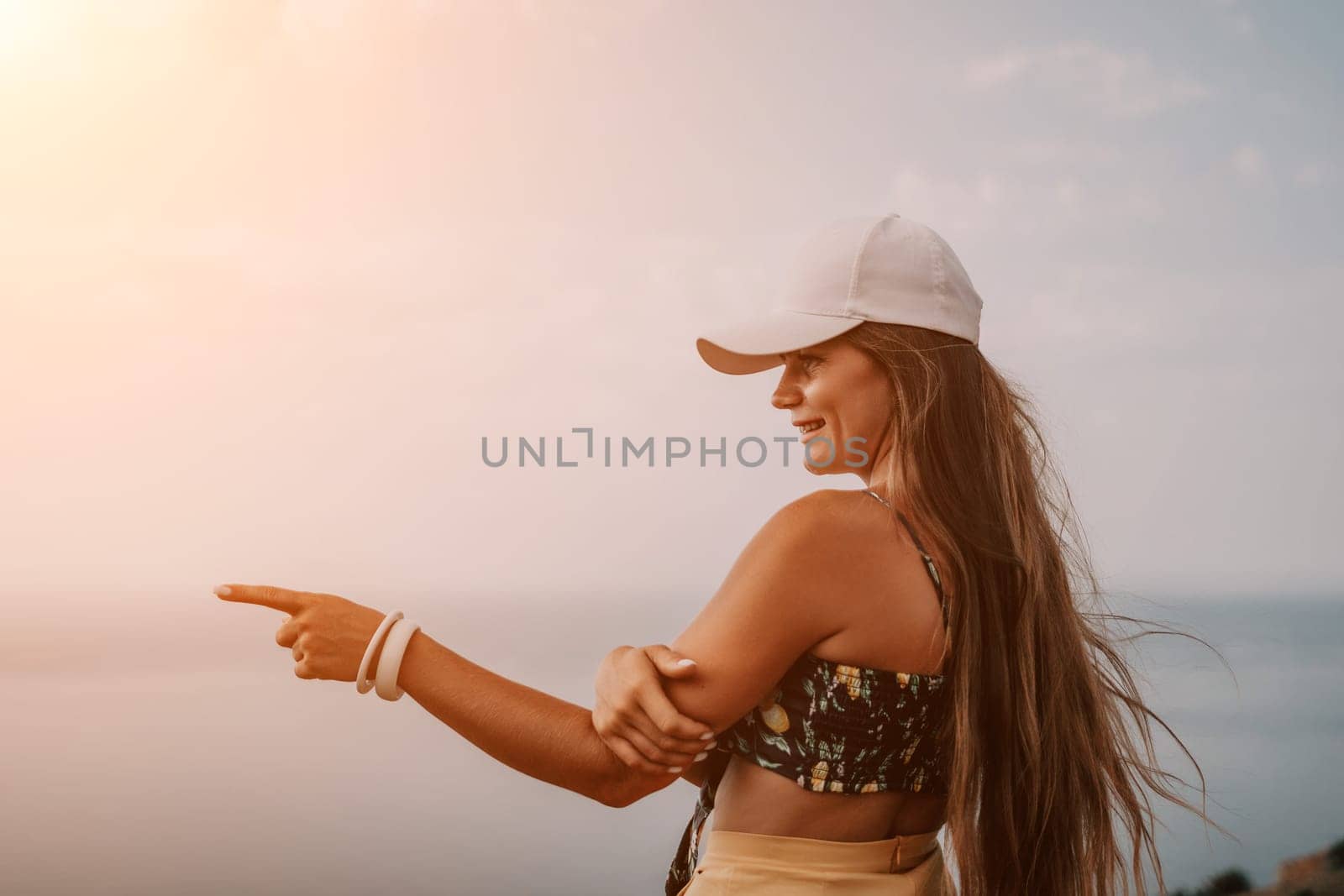 Woman travel sea. Happy tourist taking picture outdoors for memories. Woman traveler looks at the edge of the cliff on the sea bay of mountains, sharing travel adventure journey.