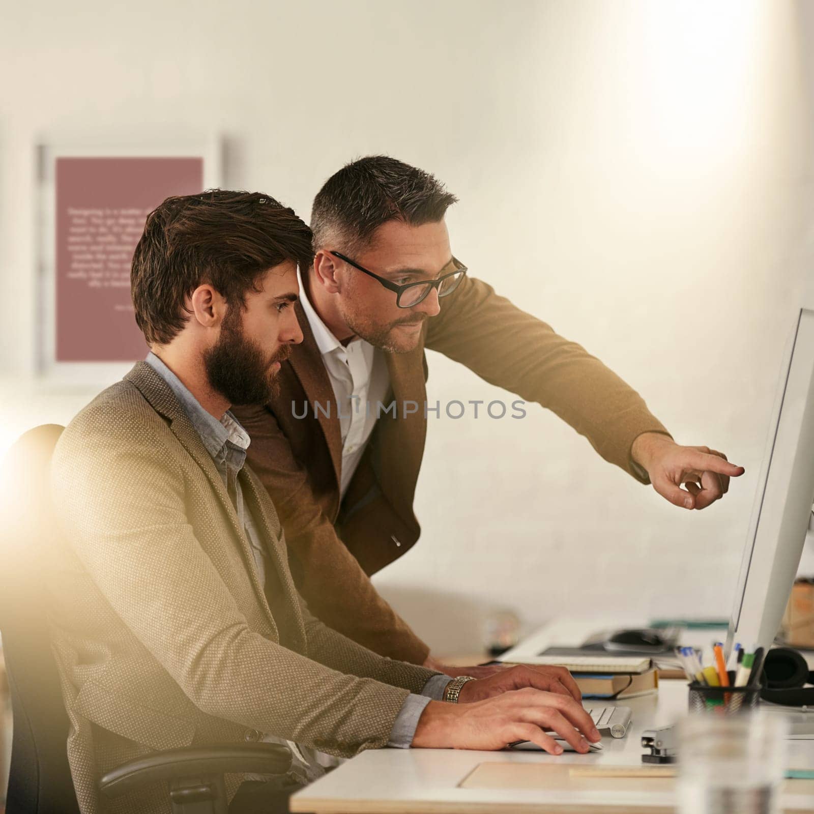 We rise by lifting others. two designers discussing something on a computer screen