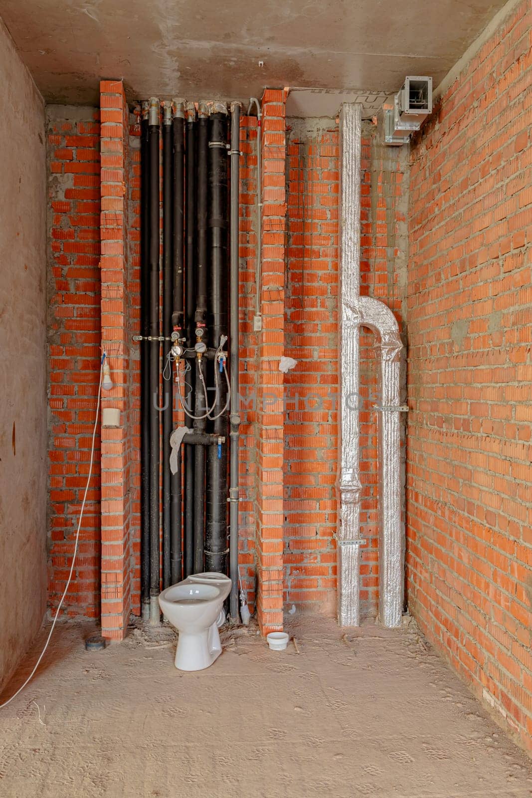 Repair and restoration of apartments. Red brick walls, concrete floors. Drain pipes and toilet