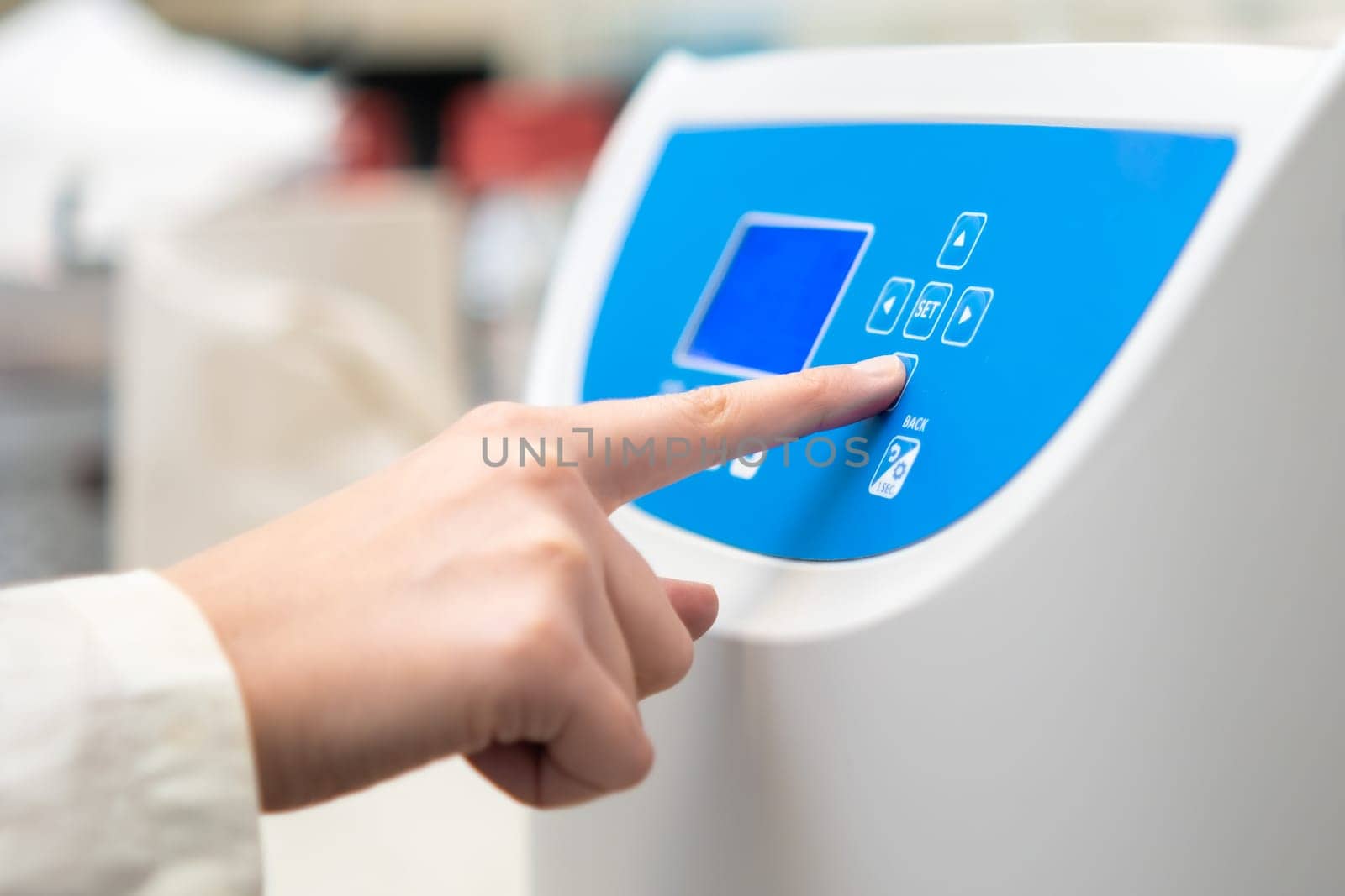 Woman sets parameters on the centrifuge for sample preparation. DNA, oncology marker analysis in clinical laboratory.