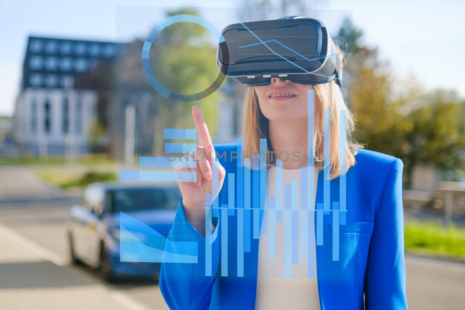 Young woman using virtual reality goggles to analyze data and graphics in colorful neon lights. Futuristic future concept in business.