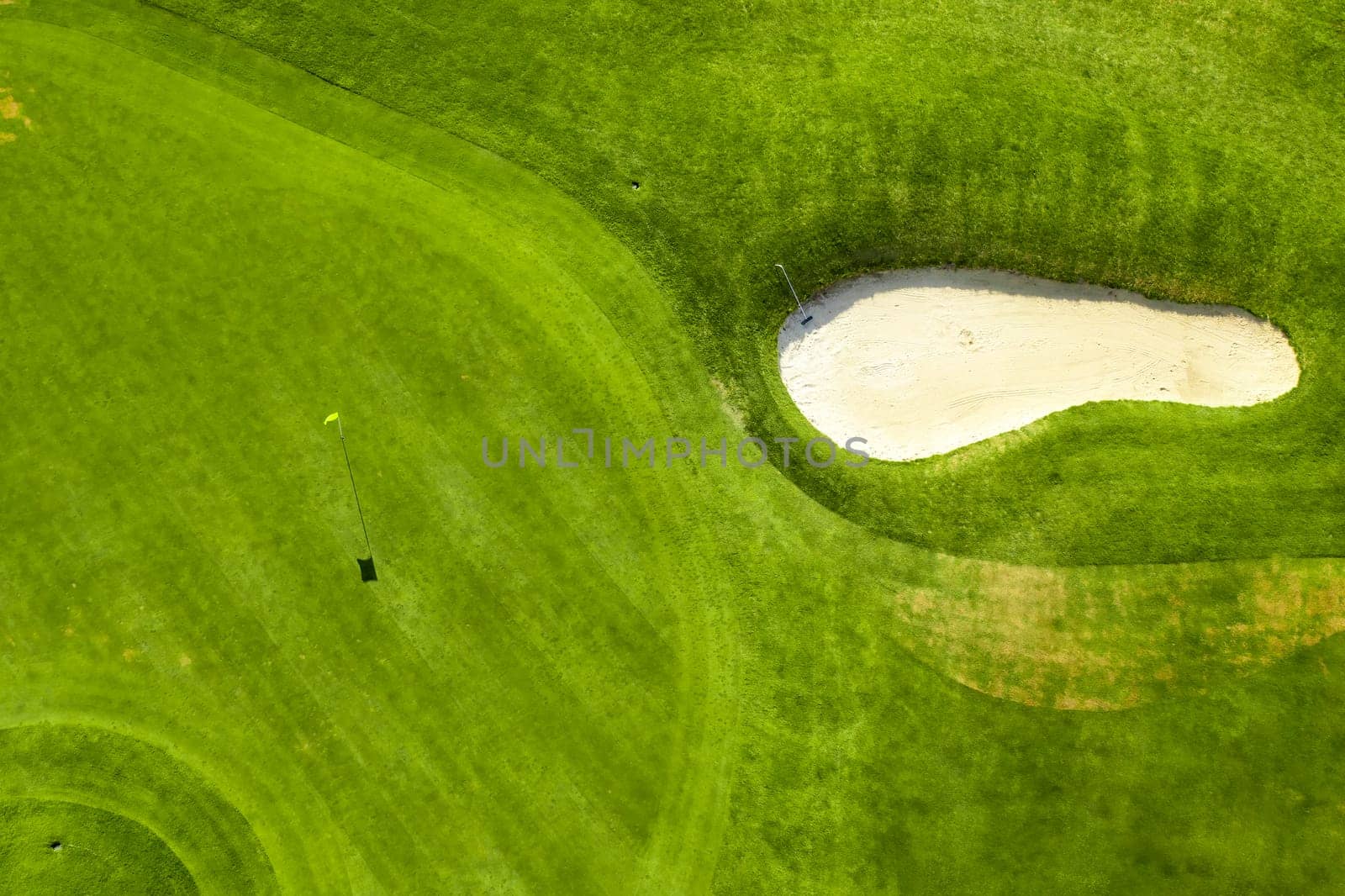 Aerial view of bunkers sand in golf court with putting green grass.