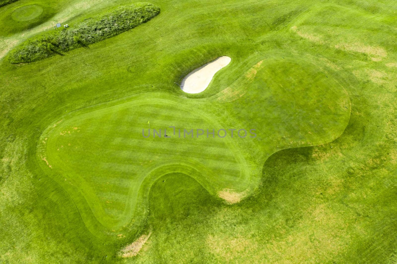 Aerial view of bunkers sand in golf court with putting green grass.
