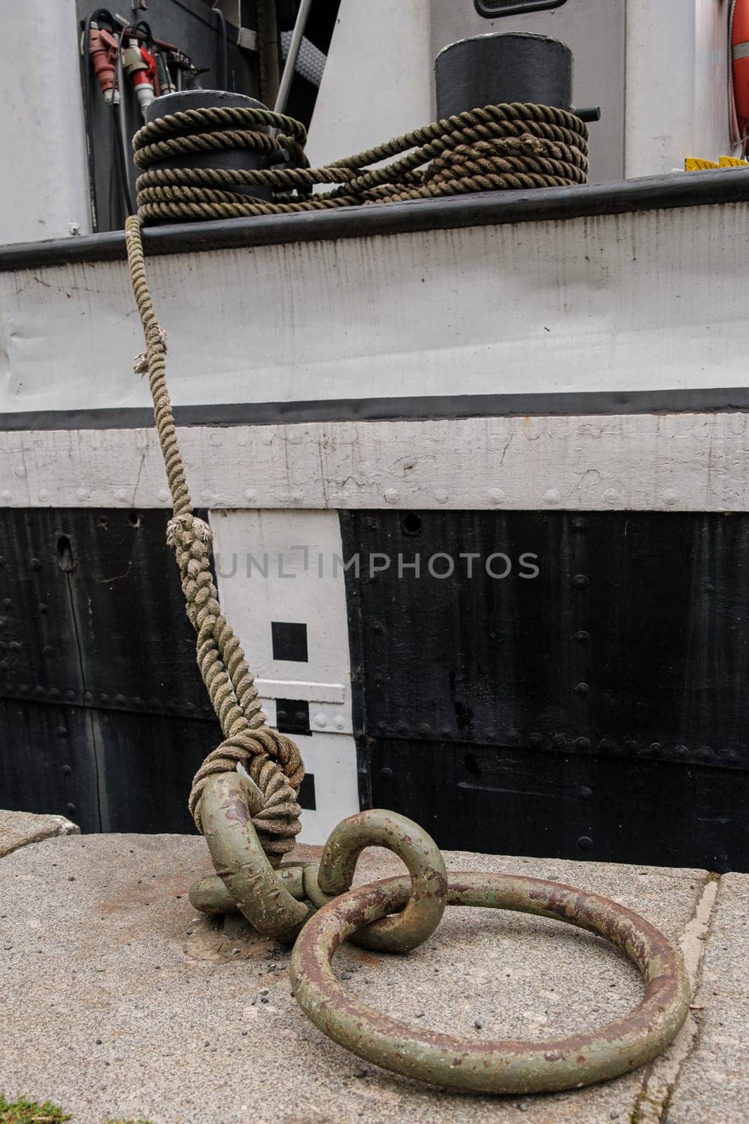Ship or vessel moored on the embankment using tensioned rope and metal ring.