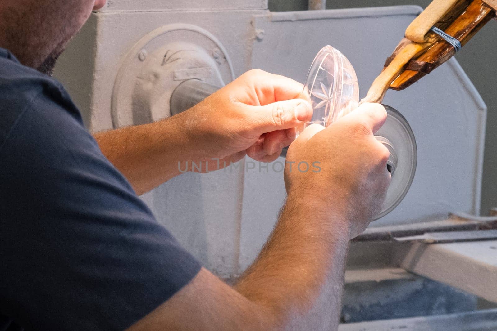 Close up mans hand making a glass carving on the new vase