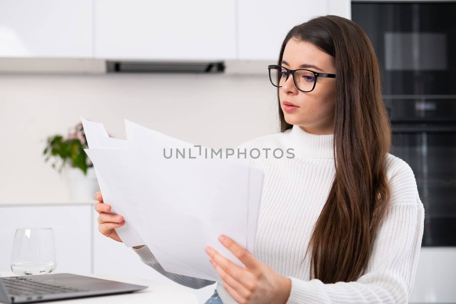 Serious millennial girl in modern glasses working with documents by vladimka