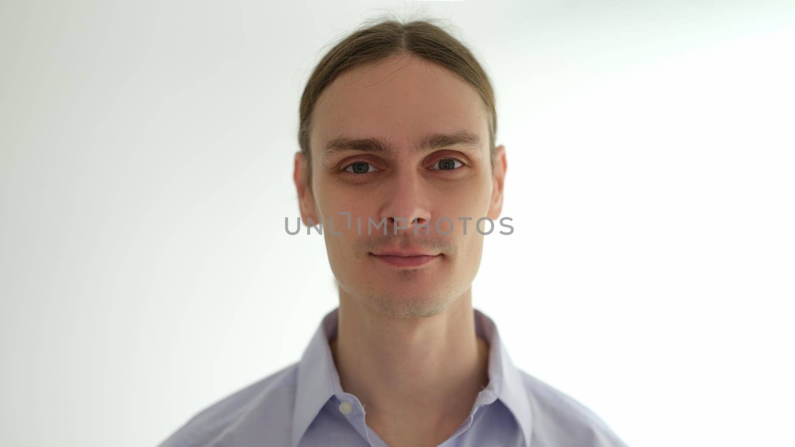 Portrait of young caucasian man with long hair on white background. Natural male beauty concept
