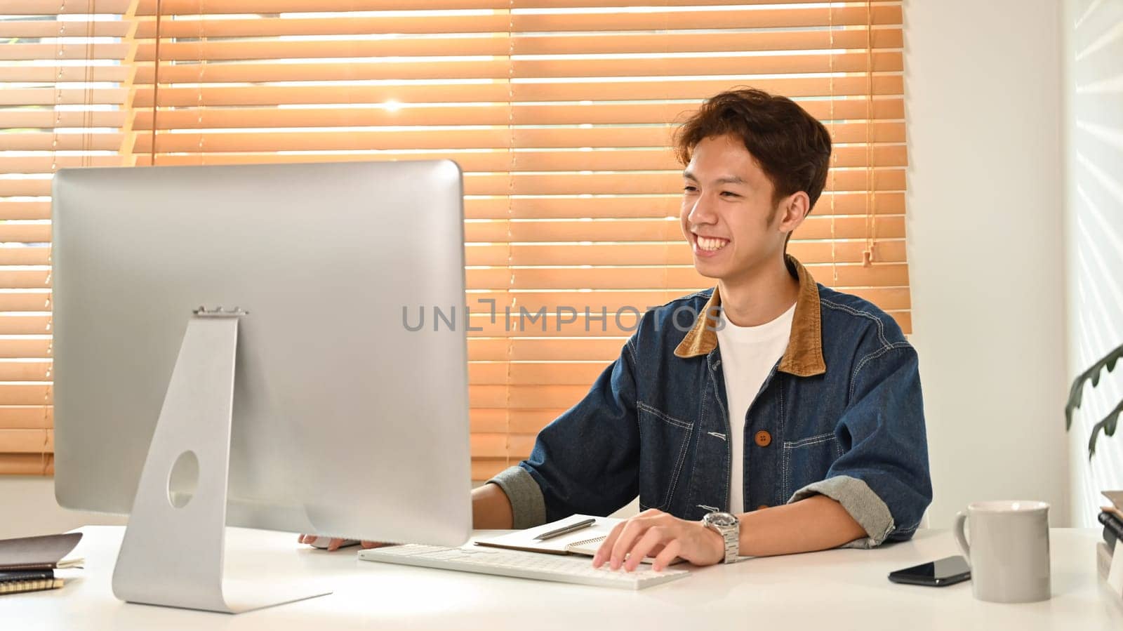 Image of asian male in smart casual wears using laptop at home office. Freelance, distance, education, e-learning concept.